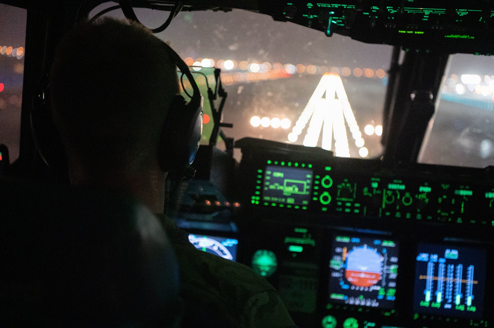 Photo of a pilot landing on a runway at night
