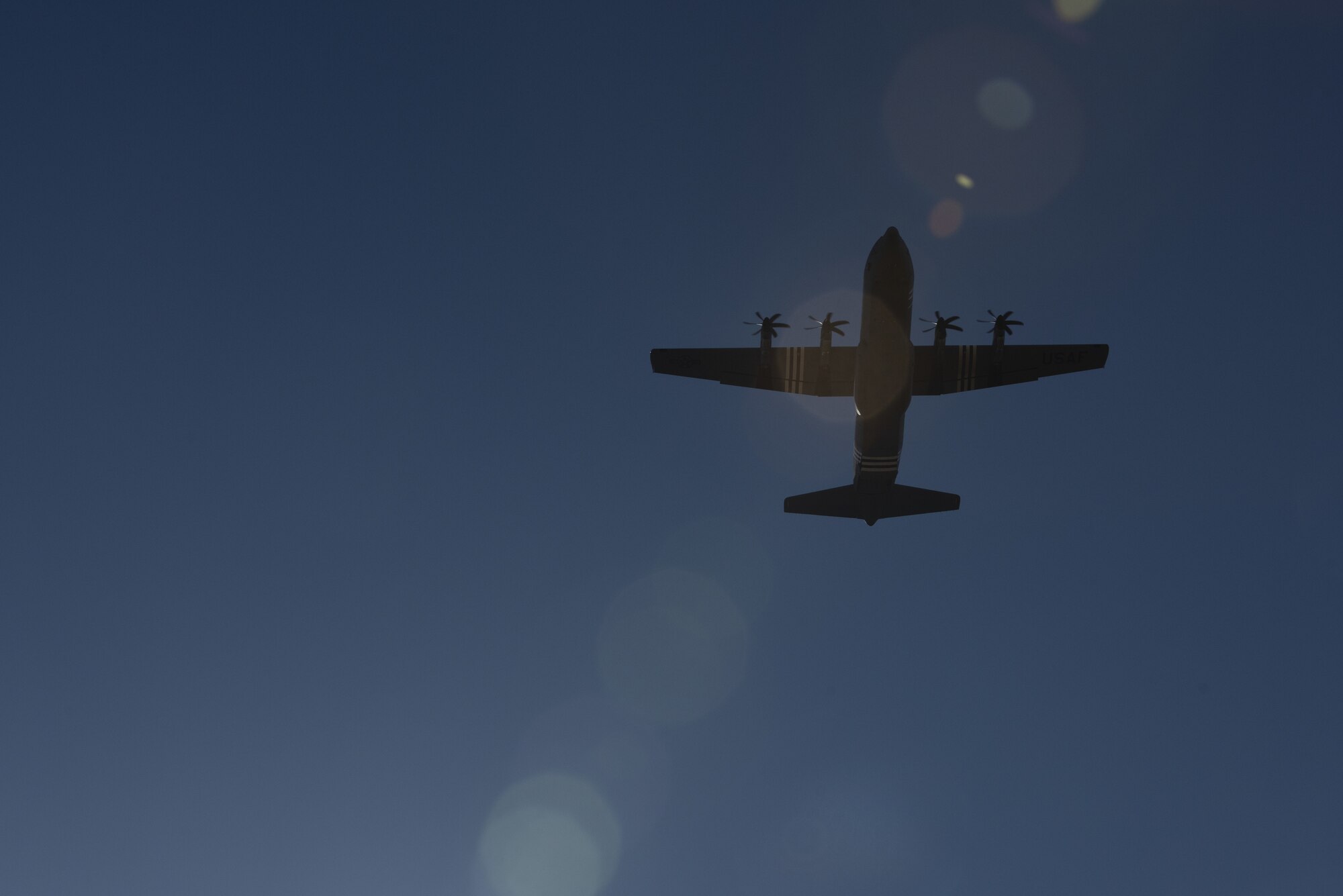A C-130J flies directly overhead