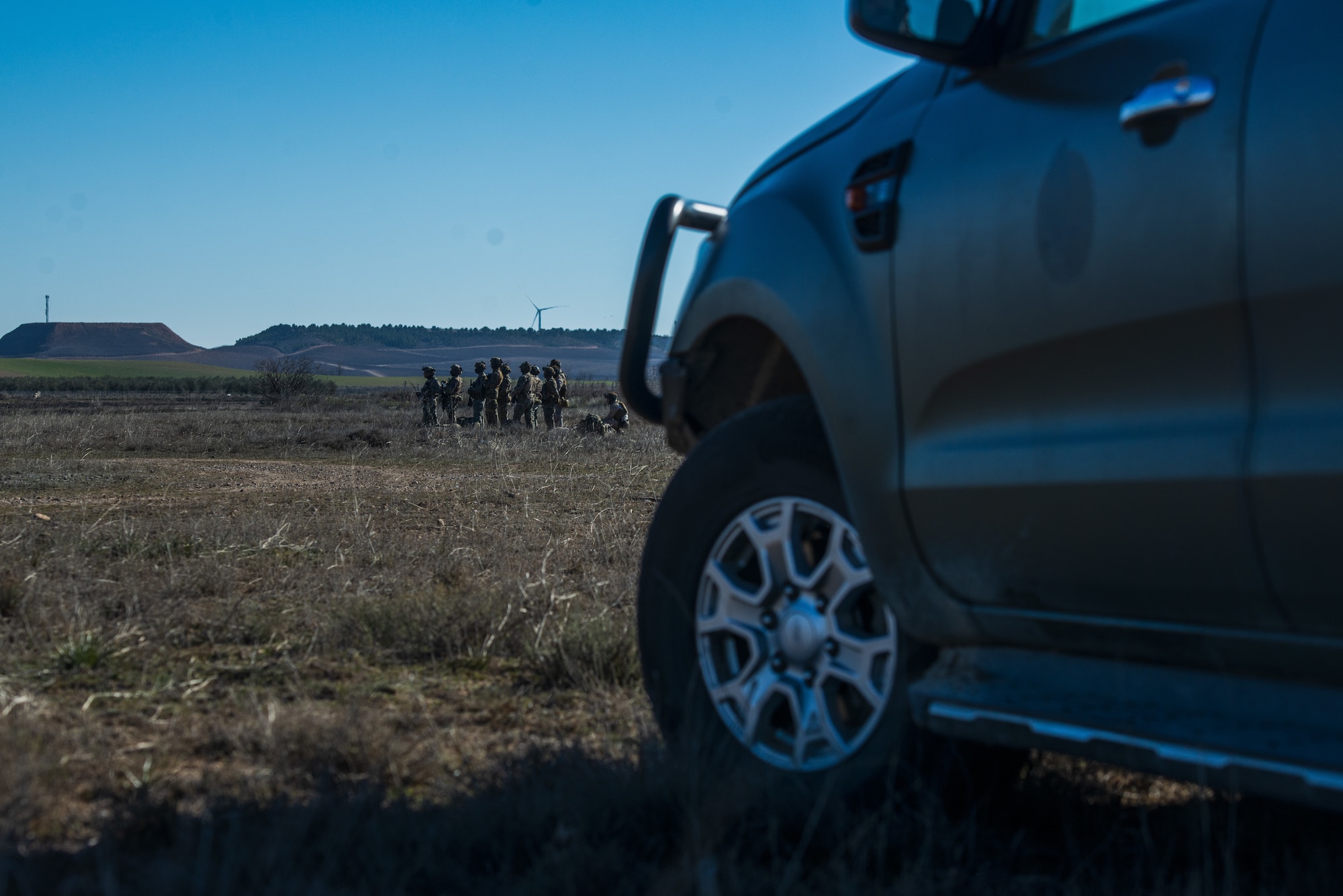 A view of a group of people from behind a truck.