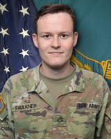 Male Soldier standing in front of two flags.