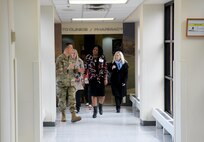 Photo shows group of people walking down hallway