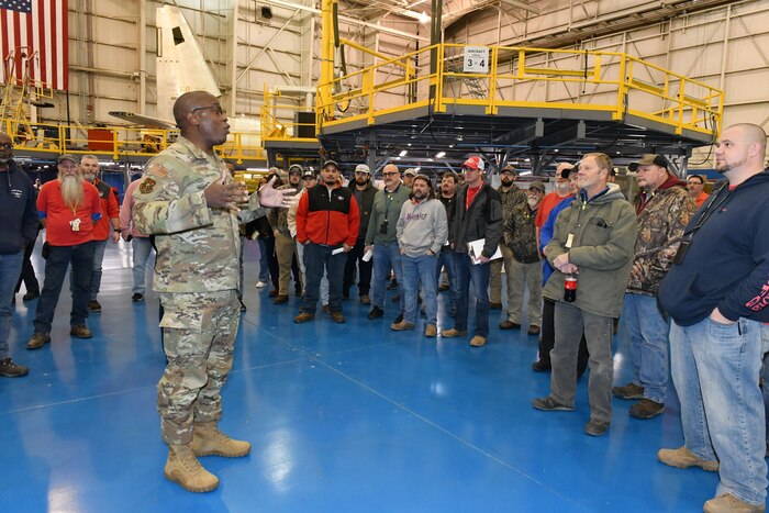 Photo shows Gen. Hawkins speaking to large group in a hangar