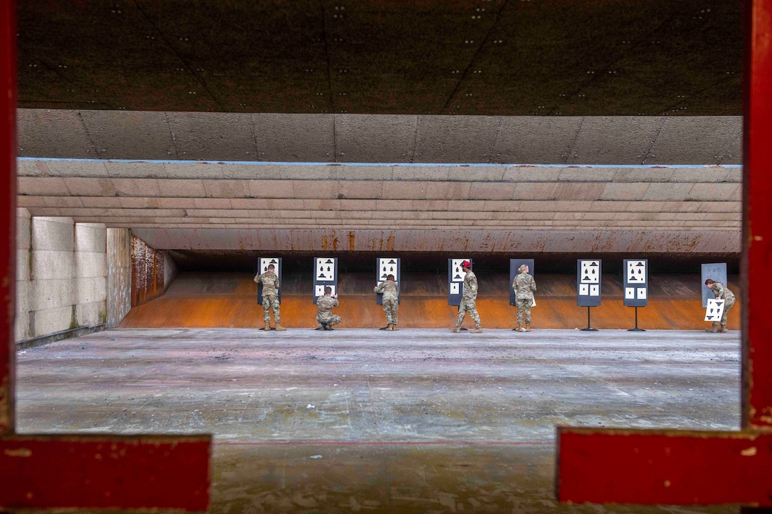 Airmen assemble targets at a firing range.
