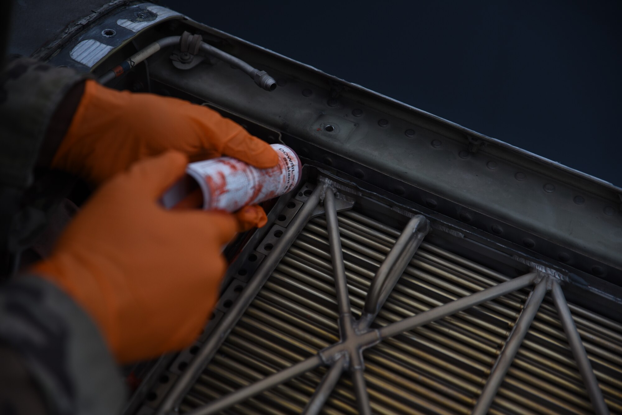 U.S. Air Force Airman 1st Class Kendall Pleasant, electrical and environmental journeyman with the 62d Aircraft Maintenance Squadron, applies sealant to a C-17 Globemaster III at Joint Base Lewis-McChord, Washington, Feb. 3, 2023. Sealant is used to reinforce aircraft parts to improve structural integrity and prevent the passage of air and fluids. (U.S. Air Force photo by Airman Kylee Tyus)