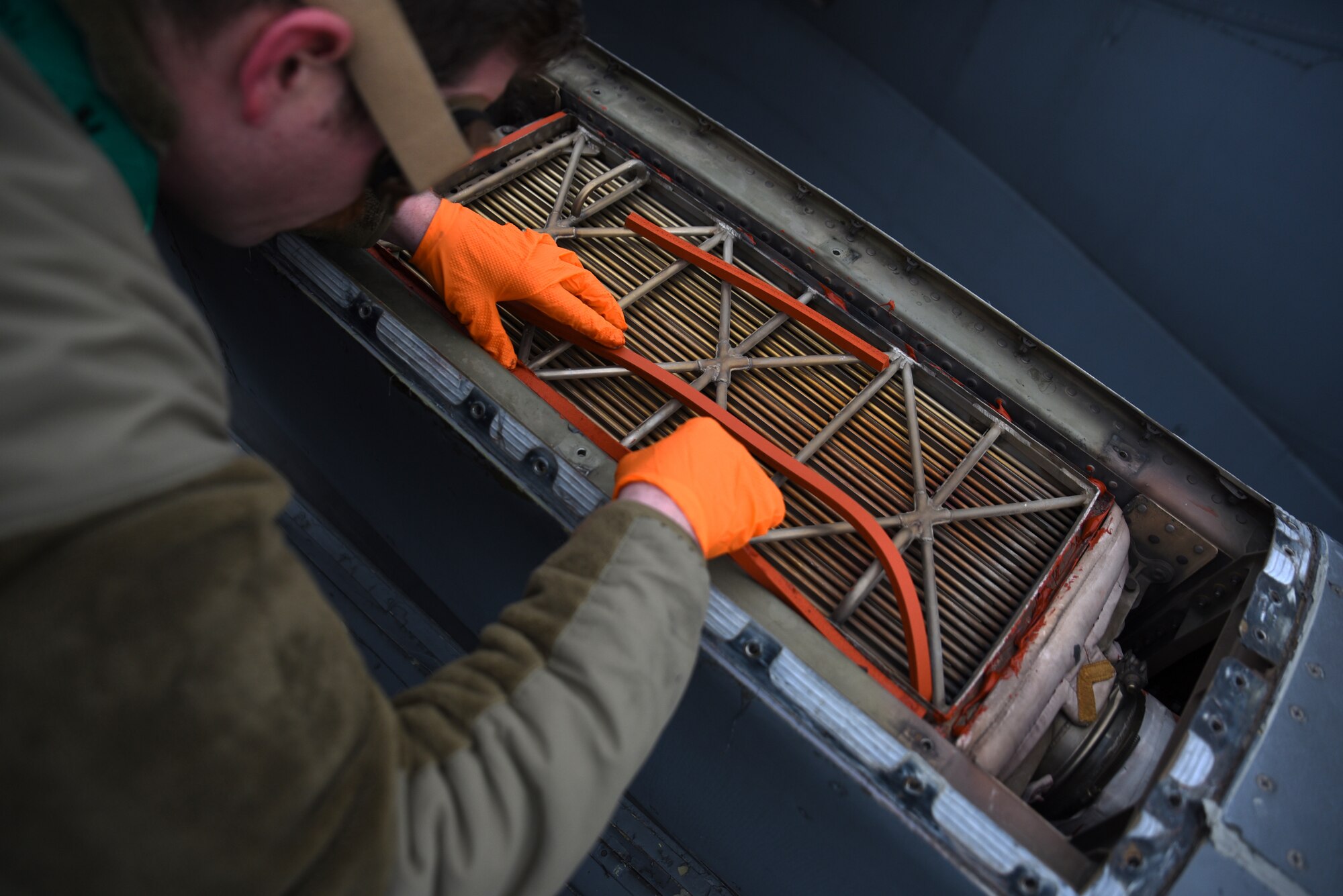 U.S. Air Force Airman 1st Class Travis Miller, electrical and environmental journeyman with the 62d Aircraft Maintenance Squadron, installs seals on the engine precooler on a C-17 Globemaster III at Joint Base Lewis-McChord, Washington, Feb. 3, 2023. The precooler cools the hot engine air to a suitable level for use in the air conditioning system. (U.S. Air Force photo by Airman Kylee Tyus)