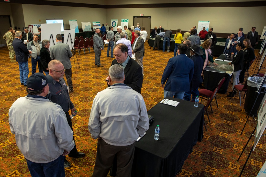 overhead view of many people in a civic center events room talking to eachother