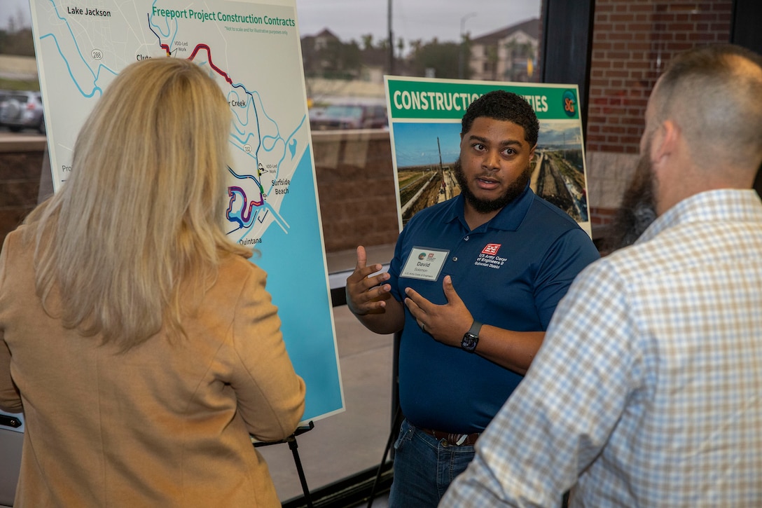 one person talking to two people in front of a graphic on an easel