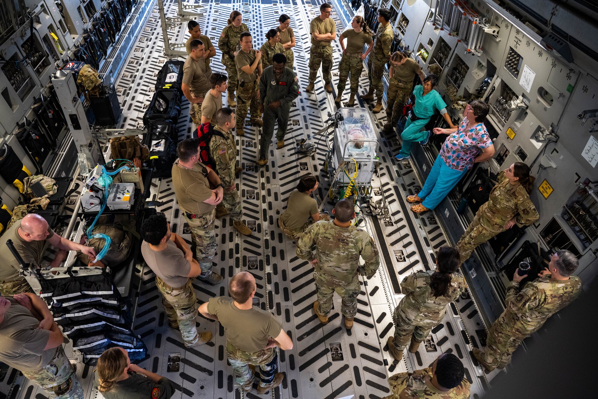 Airmen and soldiers from the 15th Medical Group and Tripler Army Medical Center attend a Neonatal and Critical Care Air Transport Team training at Joint Base Pearl Harbor-Hickam, Hawaii, Feb. 6, 2022. The training focused on safely and efficiently loading and securing a NICU transport system, and critically injured patients onto a C-17 Globemaster III. (U.S. Air Force photo by Senior Airman Makensie Cooper)