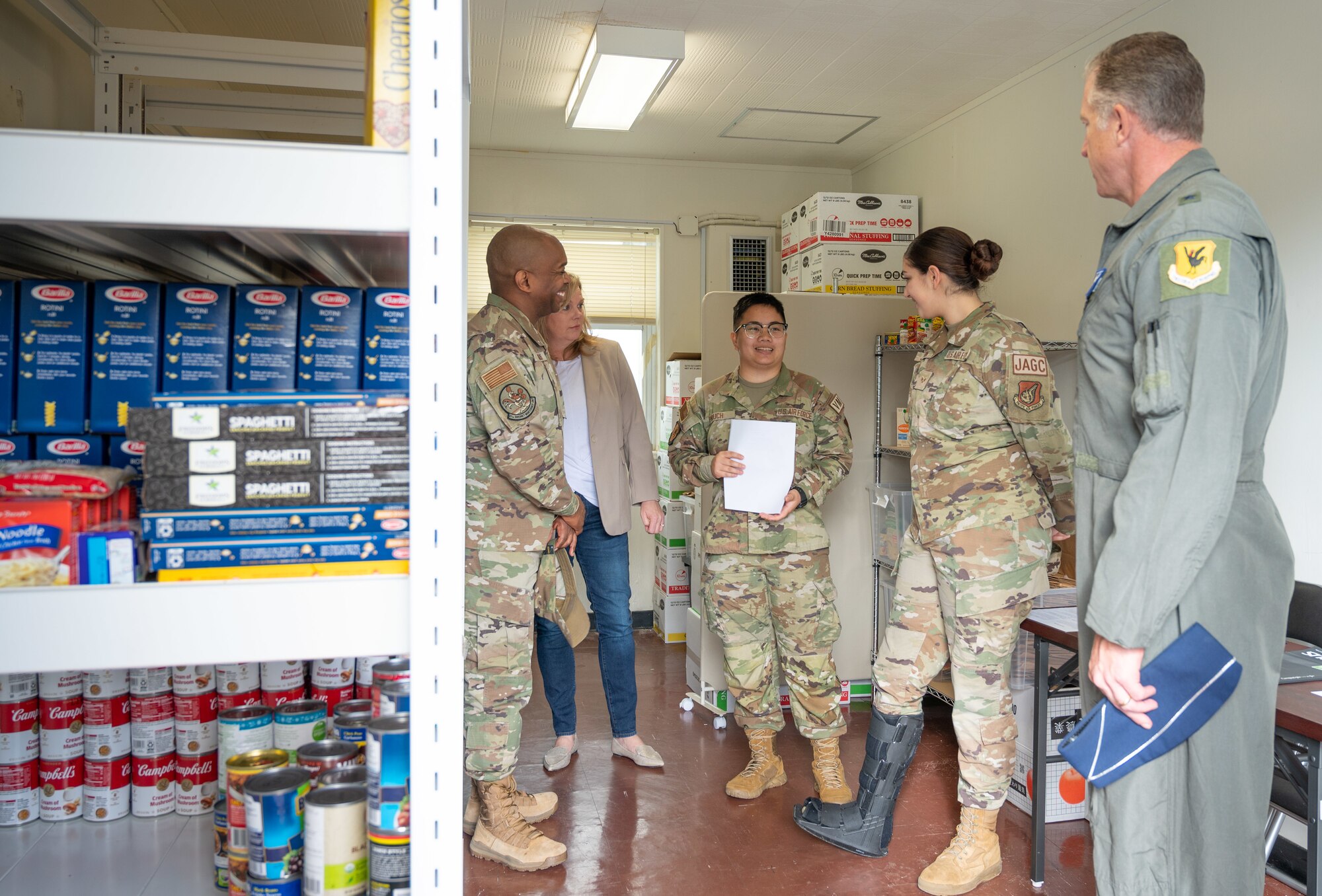 Airmen speak to each other inside of a food pantry