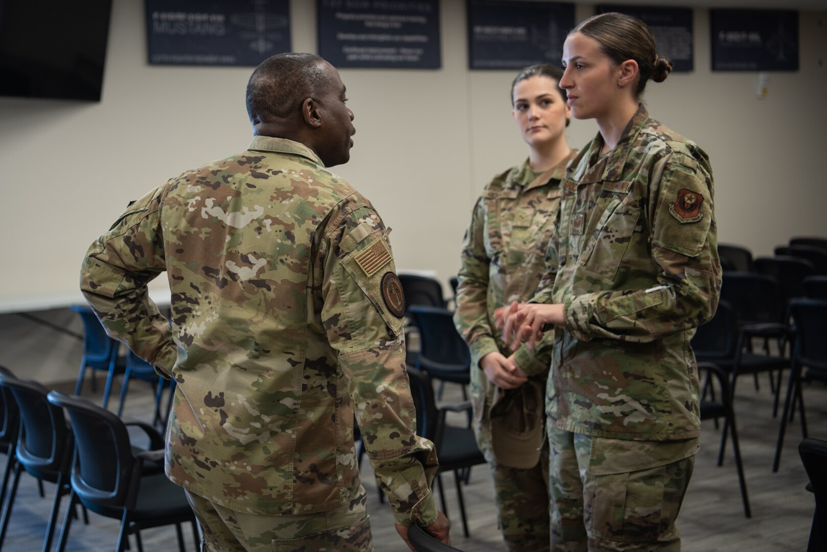 chief master sgt speaks with two airmen