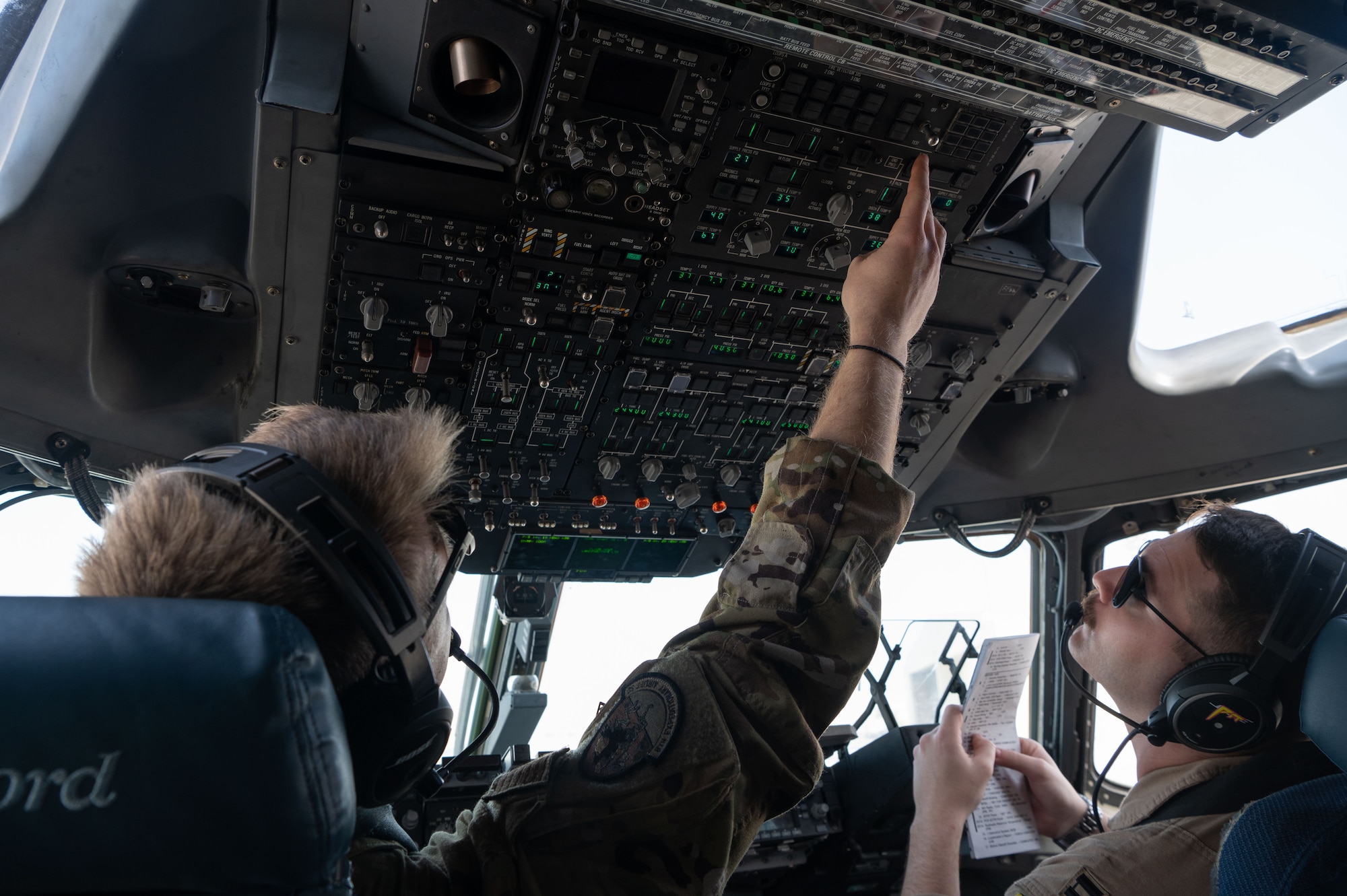 Photo of pilots doing pre-flight checks in the cockpit