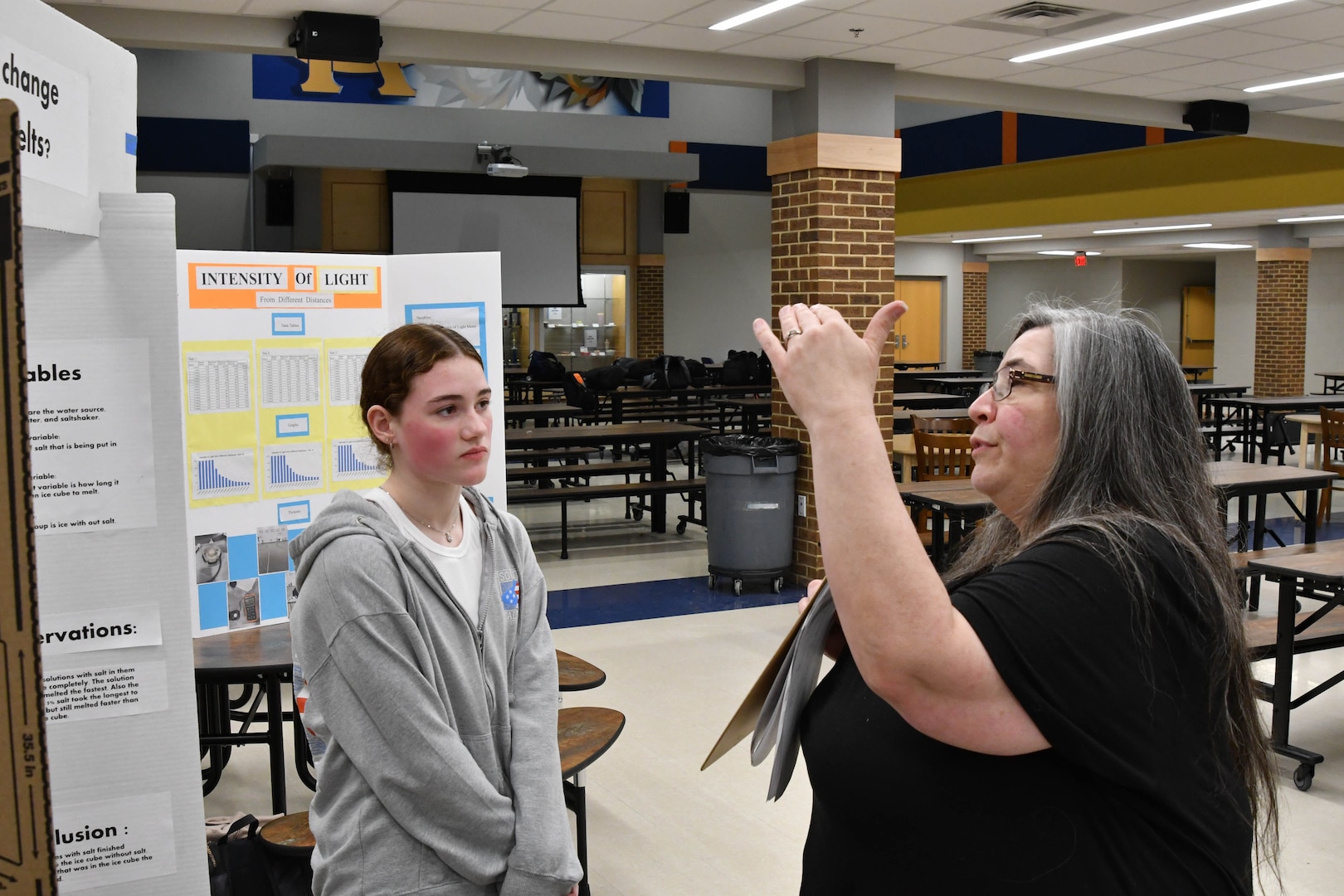 IMAGE: Julie Grossen, a branch head in the Weapons Control and Integration Department at Naval Surface Warfare Center Dahlgren Division, gives feedback to seventh-grader Madison Dougherty at the King George Middle School Science Fair Jan. 31.
