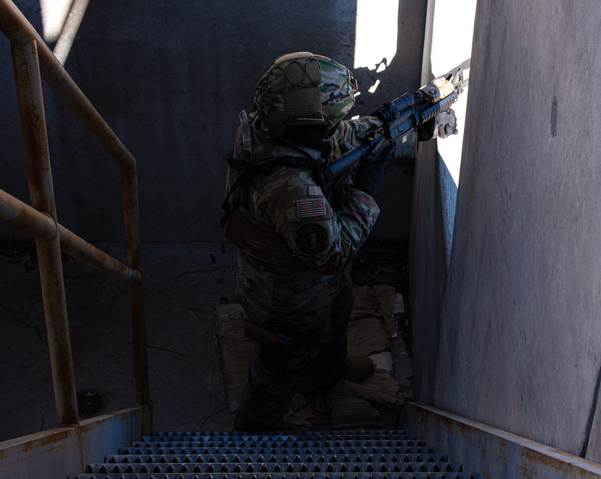 An Airman from the 22nd Security Forces Squadron guards a window while clearing a building during joint training at McConnell Air Force Base, Kansas, Feb. 3, 2023. Along with clearing buildings, the Airmen trained with U.S. Army Soldiers from the 3rd Assault Helicopter Battalion, 1st Aviation Regiment from Fort Riley, Kansas, to practice tactical takeoffs and landing in a UH-60 Blackhawk. (U.S. Air Force photo by Staff Sgt. Tryphena Mayhugh)