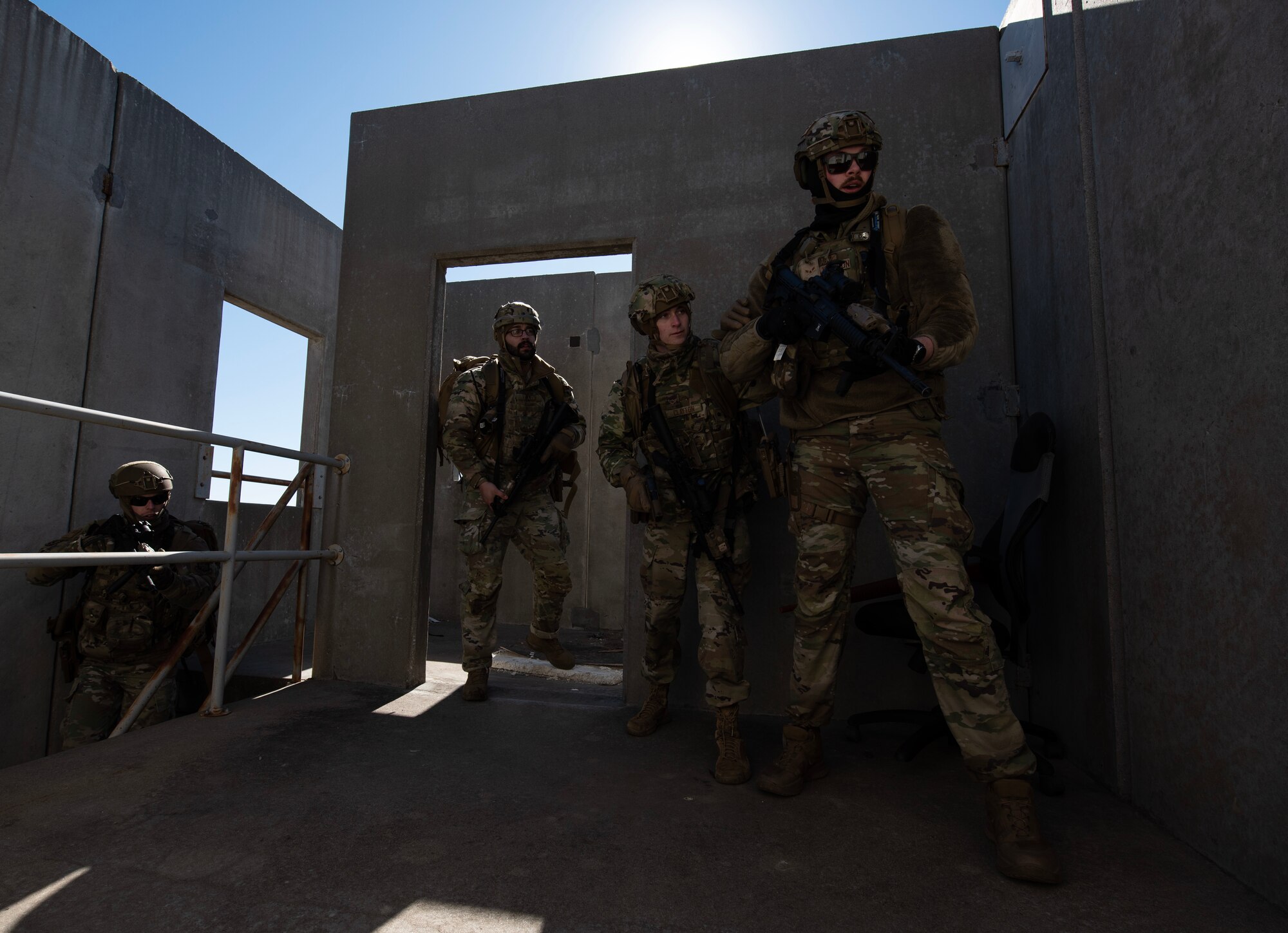 Airman 1st Class Alexander Johnson, right, and, Airman Mitchell Clayton, middle, 22nd Security Forces Squadron patrolmen, and other defenders practice clearing a building during joint training at McConnell Air Force Base, Kansas, Feb. 3, 2023. Along with clearing buildings, the Airmen trained with U.S. Army Soldiers from the 3rd Assault Helicopter Battalion, 1st Aviation Regiment from Fort Riley, Kansas, to practice tactical takeoffs and landings in a UH-60 Blackhawk. (U.S. Air Force photo by Staff Sgt. Tryphena Mayhugh)