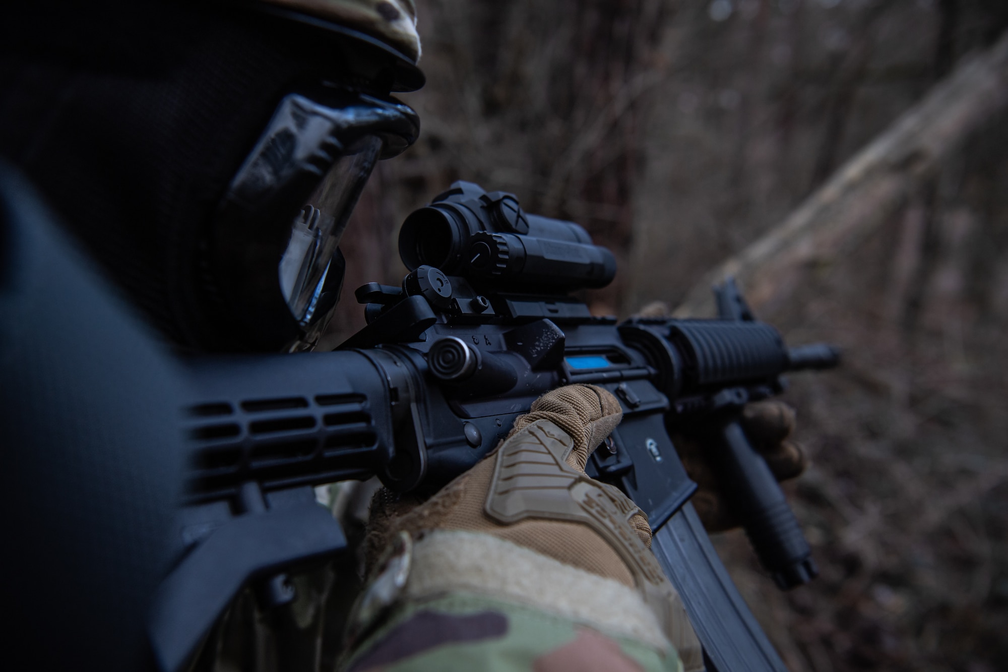 man looks through gun scope