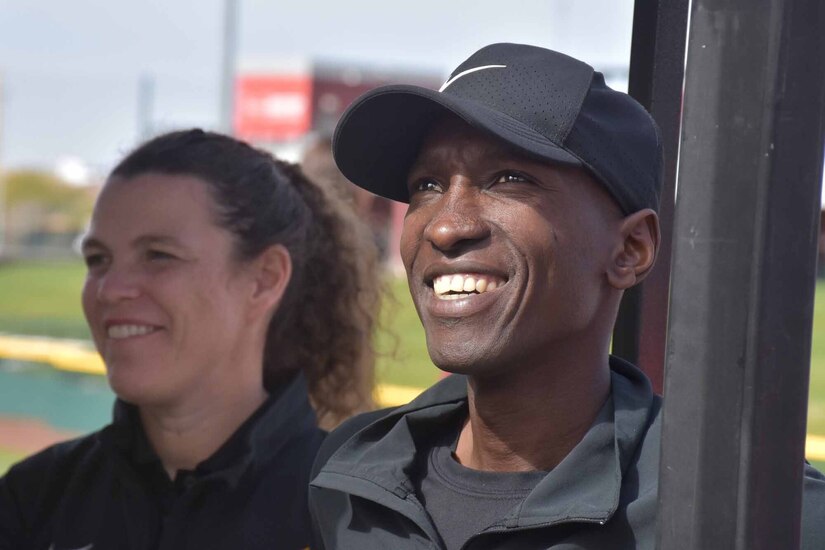 Two people smile as they watch activities.