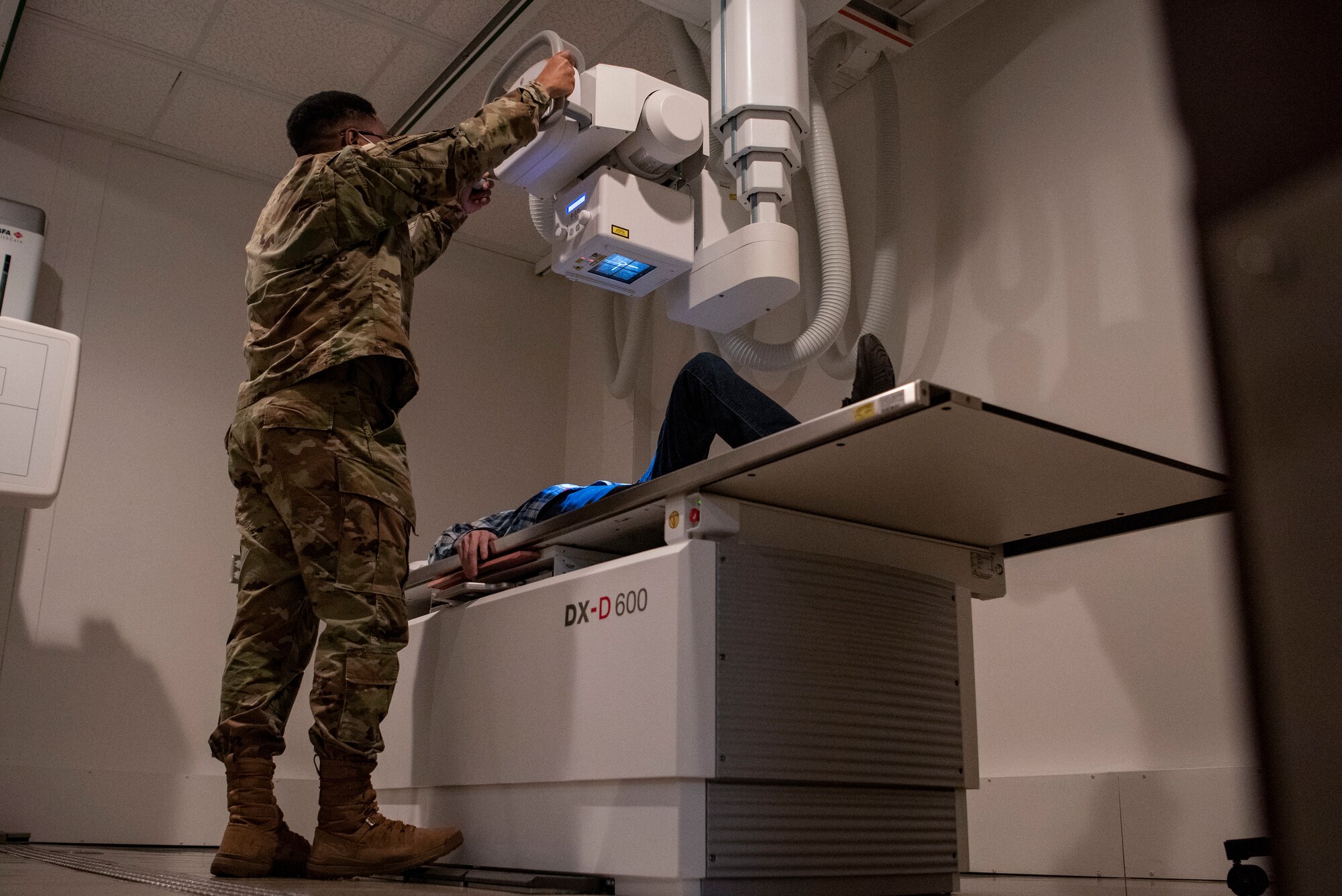 U.S. Air Force Staff Sgt. Edward Smith, 7th Health Care Operations Squadron diagnostic imaging technologist, demonstrates the functions of an X-ray machine at Dyess Air Force Base, Texas, Feb. 8, 2023.  The Dyess Radiology Clinic ensures military personnel and their families receive quality health care by taking X-ray images that are digitally transmitted through the picture archiving and communication system to be read by a radiologist at Travis AFB, California. (U.S. Air Force photo by Airman 1st Class Ryan Hayman)