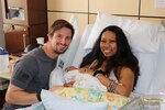 Parents post with newborn in hospital