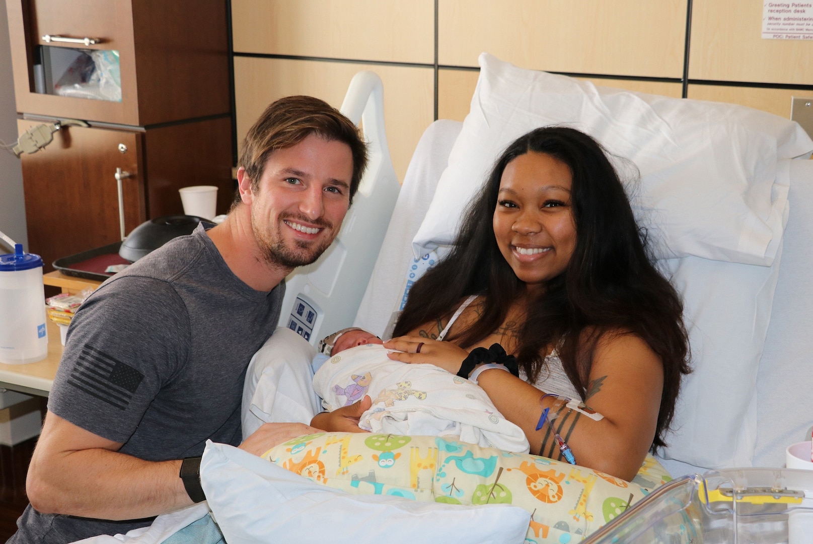 Parents post with newborn in hospital
