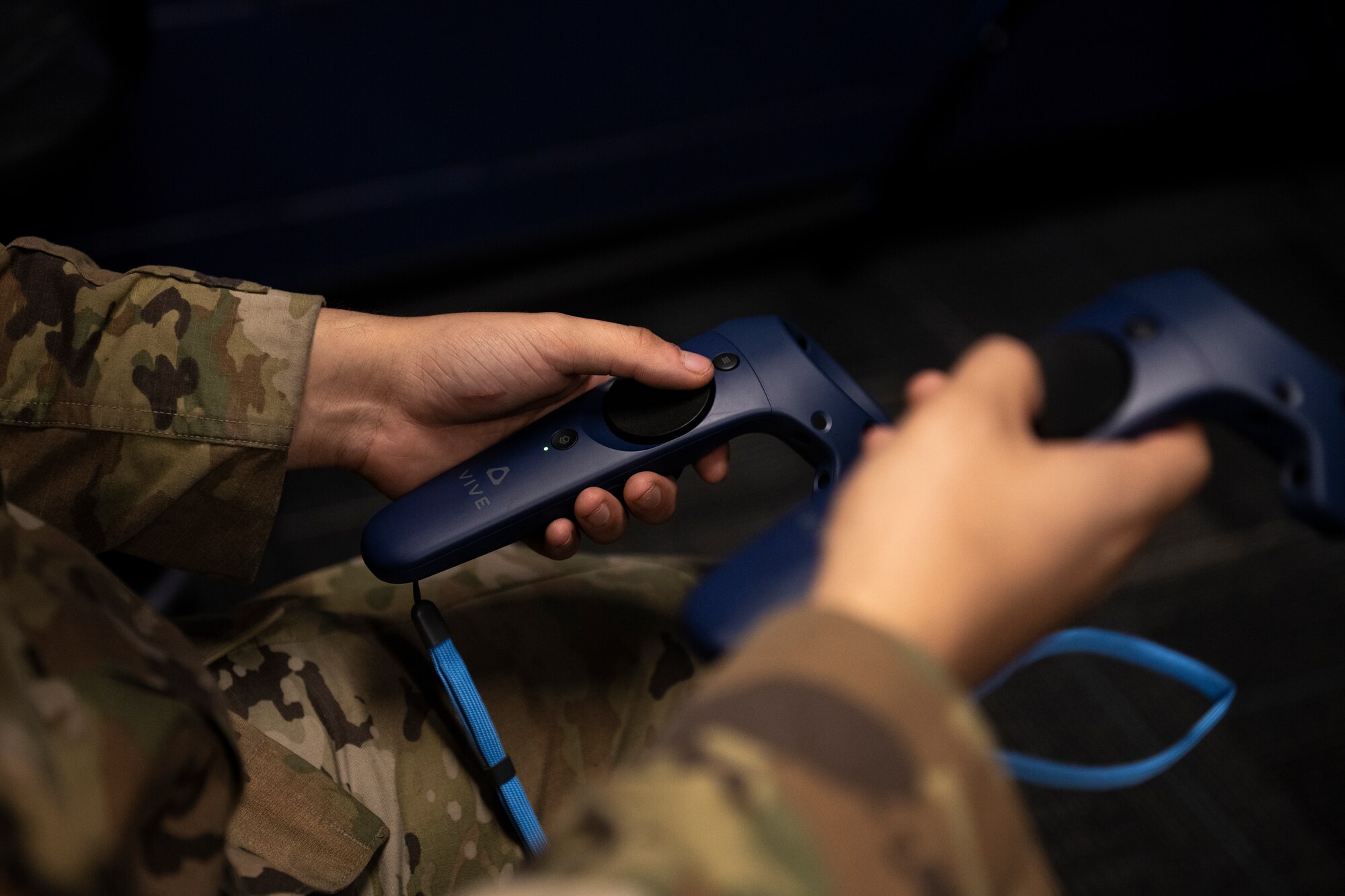 A photo a an Airman holding VR hand controllers.