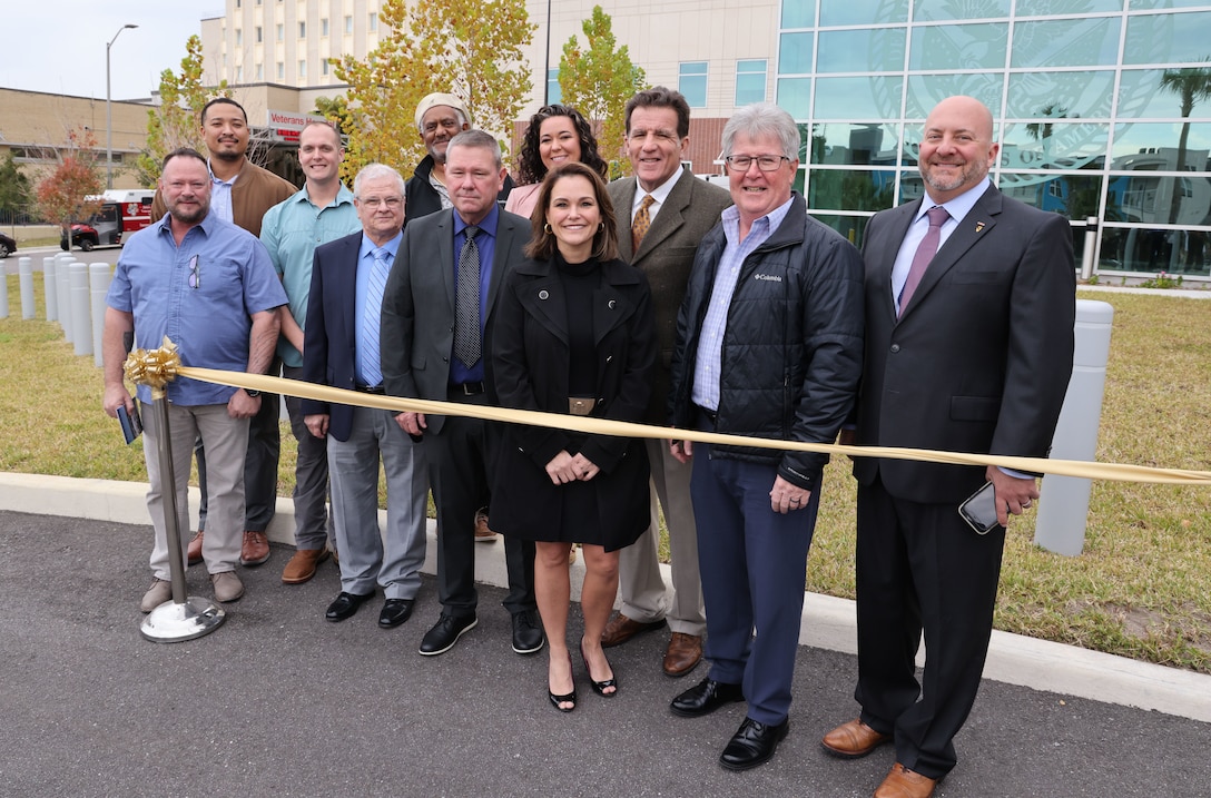 People standing at a ribbon cutting.