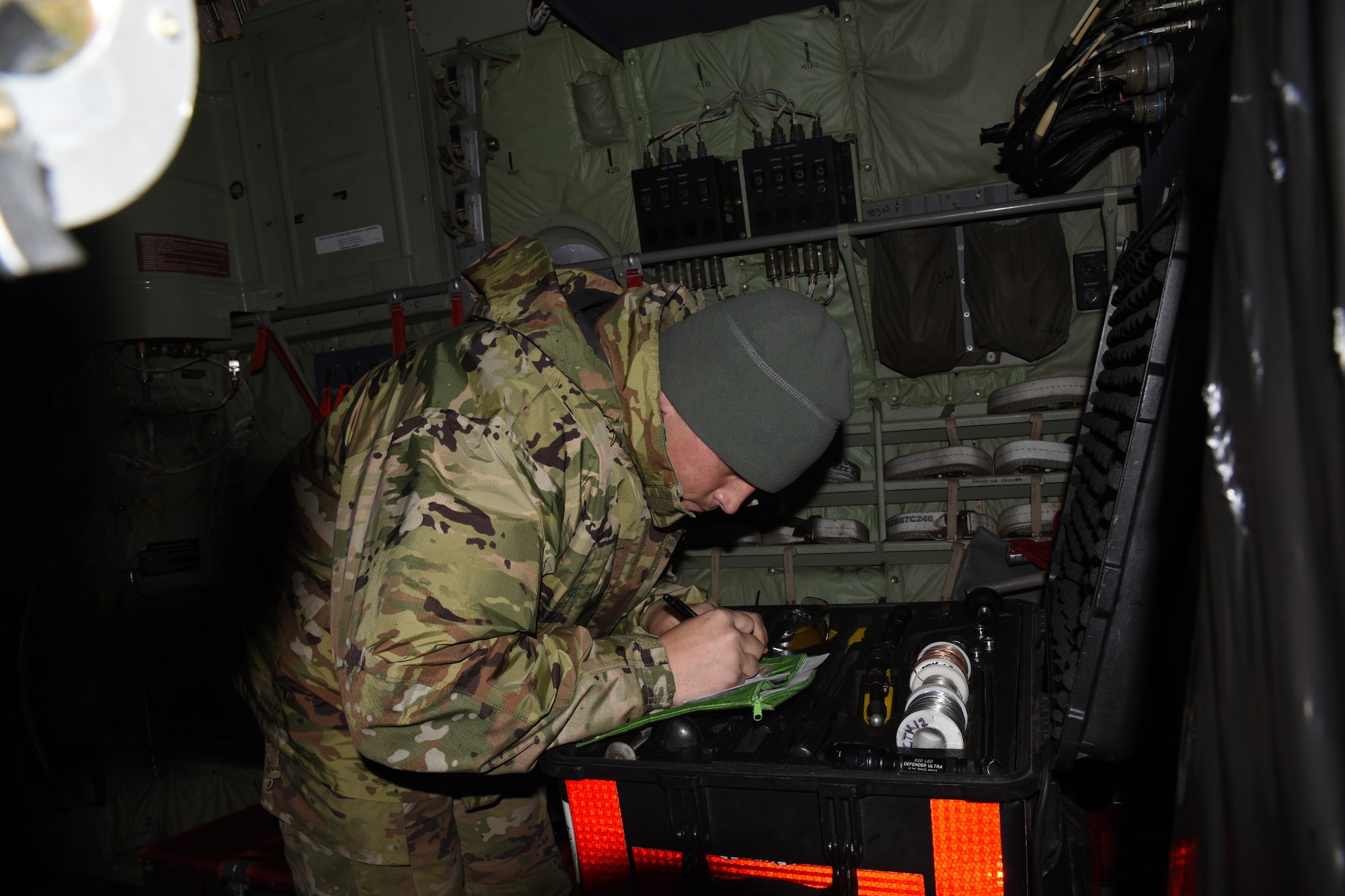 Airman counting tools in a toolbox on a WC-130J aircraft.
