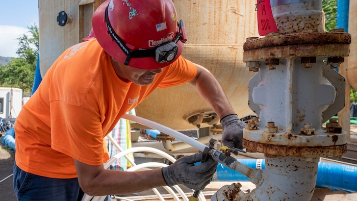 A foreman attaches an outside pipe from the water tank to an analyzer shed outside the Red Hill Bulk Fuel Storage Facility in Halawa, Hawaii, Feb. 8, 2023. Water from the aquifer is first pumped into the water tanks, which is then cycled into the analyzer shed–where the water is constantly analyzed for possible contaminants–and is then recycled back into the aquifer. (U.S. Army photo by Spc. Matthew Mackintosh)