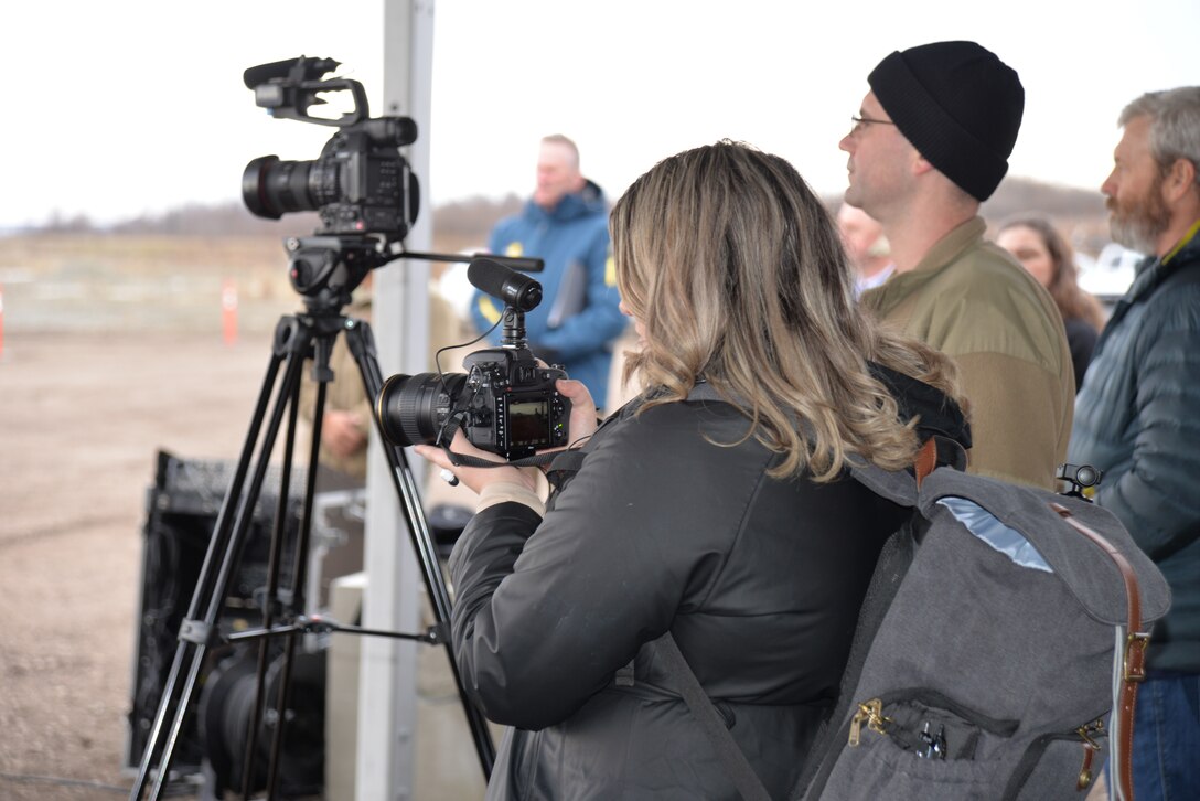 Rachel Napolitan, public affairs specialist, captures imagery at a groundbreaking ceremony for the 16/34 runway extension on Joint Base Elmendorf-Richardson, Alaska. The $309 million project requires the excavation of 12 million cubic yards of soil. Since construction efforts began in the fall, contractors have excavated 1.3 million cubic yards of soil.