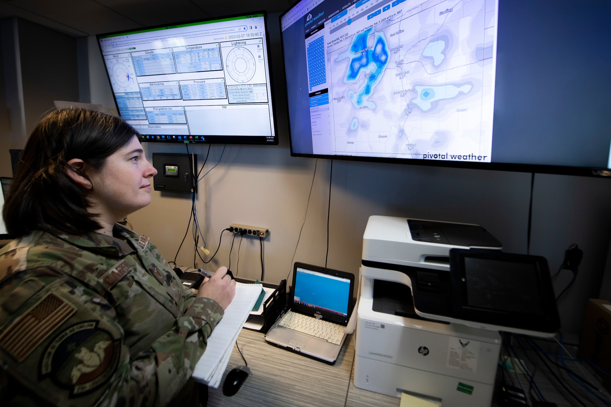 Military member reading computer monitors.