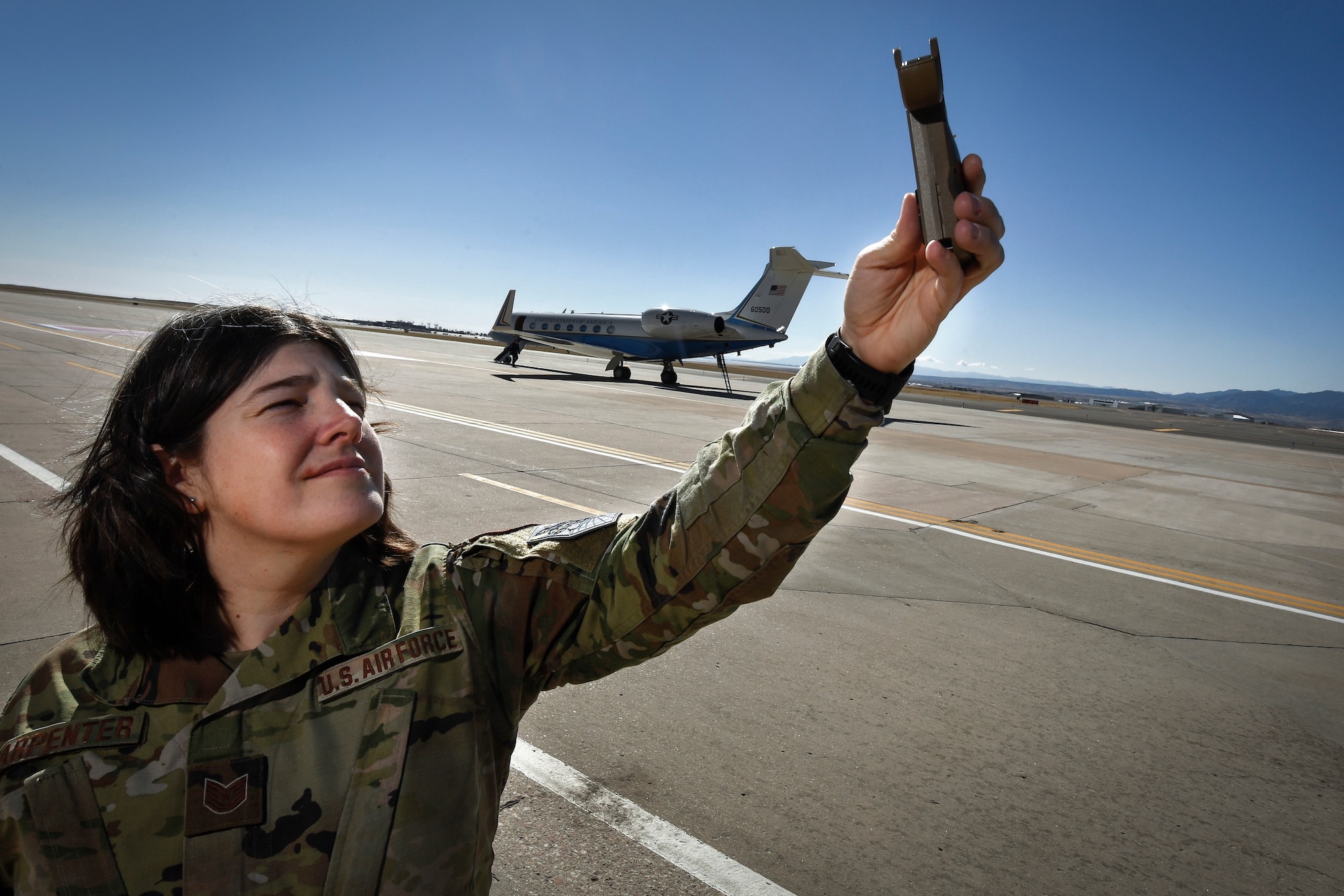Military member holding a weather reading tool