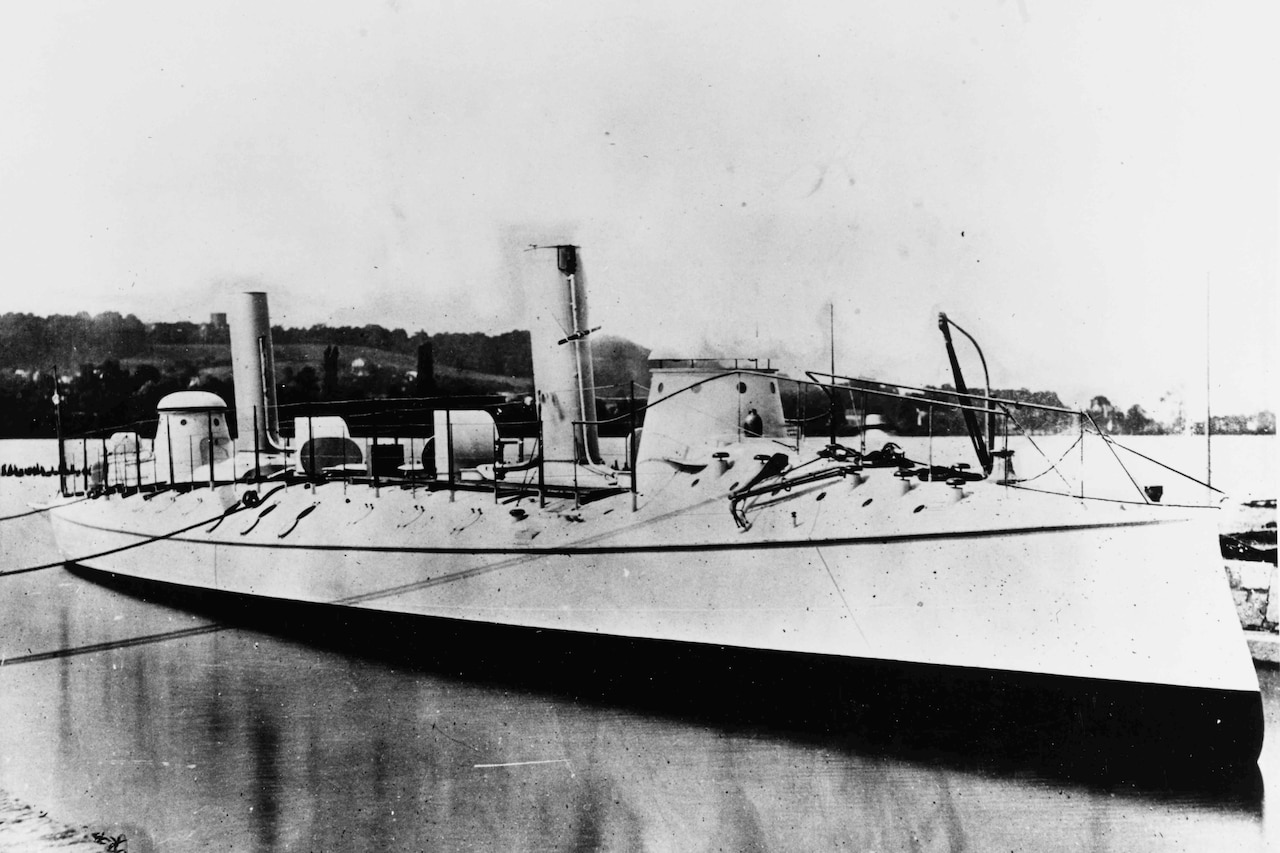 A ship with two small smokestack floats in a harbor.