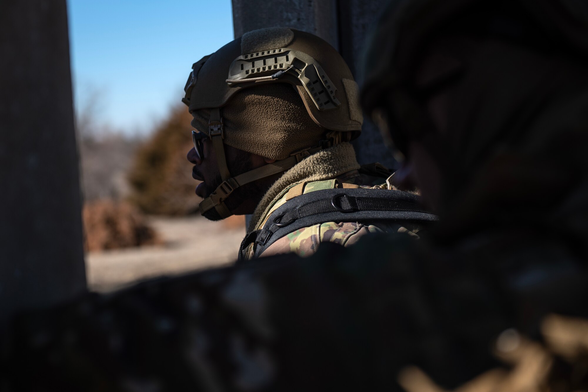 Airman 1st Class Brandon Williams, left, 22nd Security Forces Squadron patrolman, and another SFS Airman clear a building during joint training at McConnell Air Force Base, Kansas, Feb. 3, 2023. Along with clearing buildings, the Airmen trained with U.S. Army Soldiers from the 3rd Assault Helicopter Battalion, 1st Aviation Regiment from Fort Riley, Kansas, to practice tactical takeoffs and landings in a UH-60 Blackhawk. (U.S. Air Force photo by Staff Sgt. Tryphena Mayhugh)
