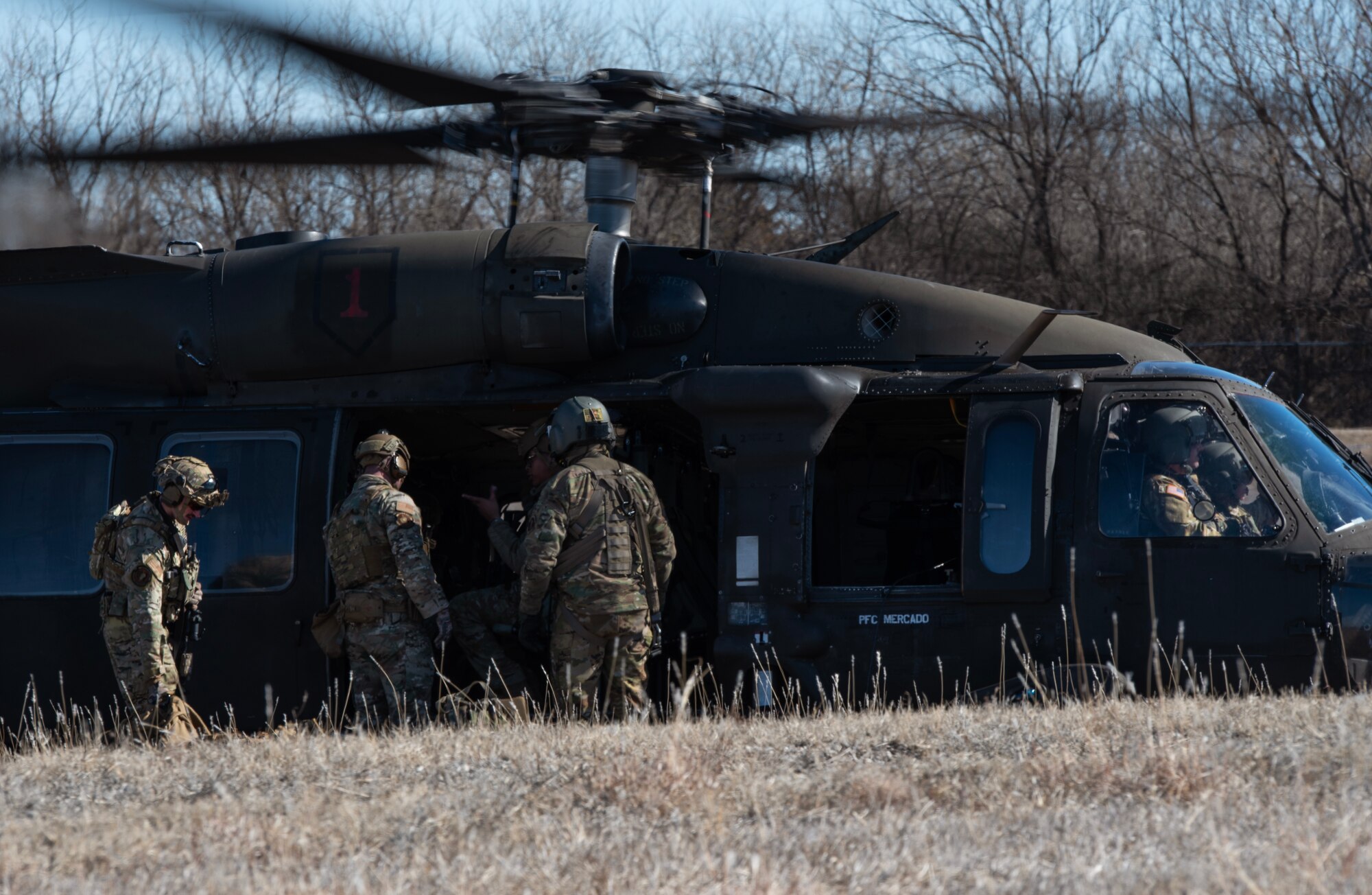 Airmen from the 22nd Security Forces Squadron load onto a U.S. Army UH-60 Blackhawk during joint training at McConnell Air Force Base, Kansas, Feb. 3, 2023. The Airmen trained with U.S. Army Soldiers from the 3rd Assault Helicopter Battalion, 1st Aviation Regiment from Fort Riley, Kansas, to practice tactical takeoffs and landings in the Blackhawk. (U.S. Air Force photo by Staff Sgt. Tryphena Mayhugh)