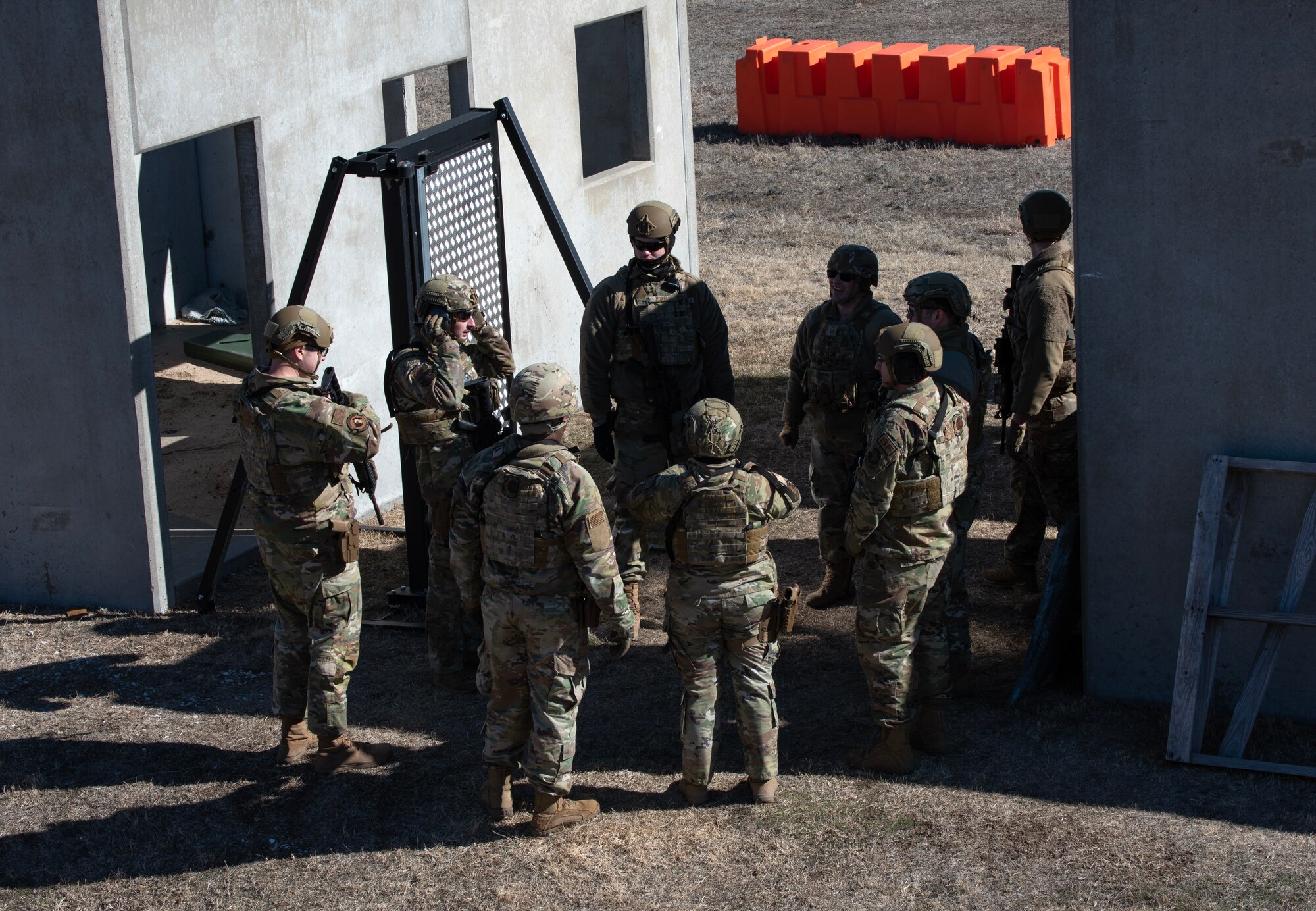 Airmen from the 22nd Security Forces Squadron conduct a briefing after joint training at McConnell Air Force Base, Kansas, Feb. 3, 2023. Along with tactical approaches and retreats to clear buildings, the Airmen trained with U.S. Army Soldiers from the 3rd Assault Helicopter Battalion, 1st Aviation Regiment from Fort Riley, Kansas, to practice tactical takeoffs and landings in a UH-60 Blackhawk. (U.S. Air Force photo by Staff Sgt. Tryphena Mayhugh)
