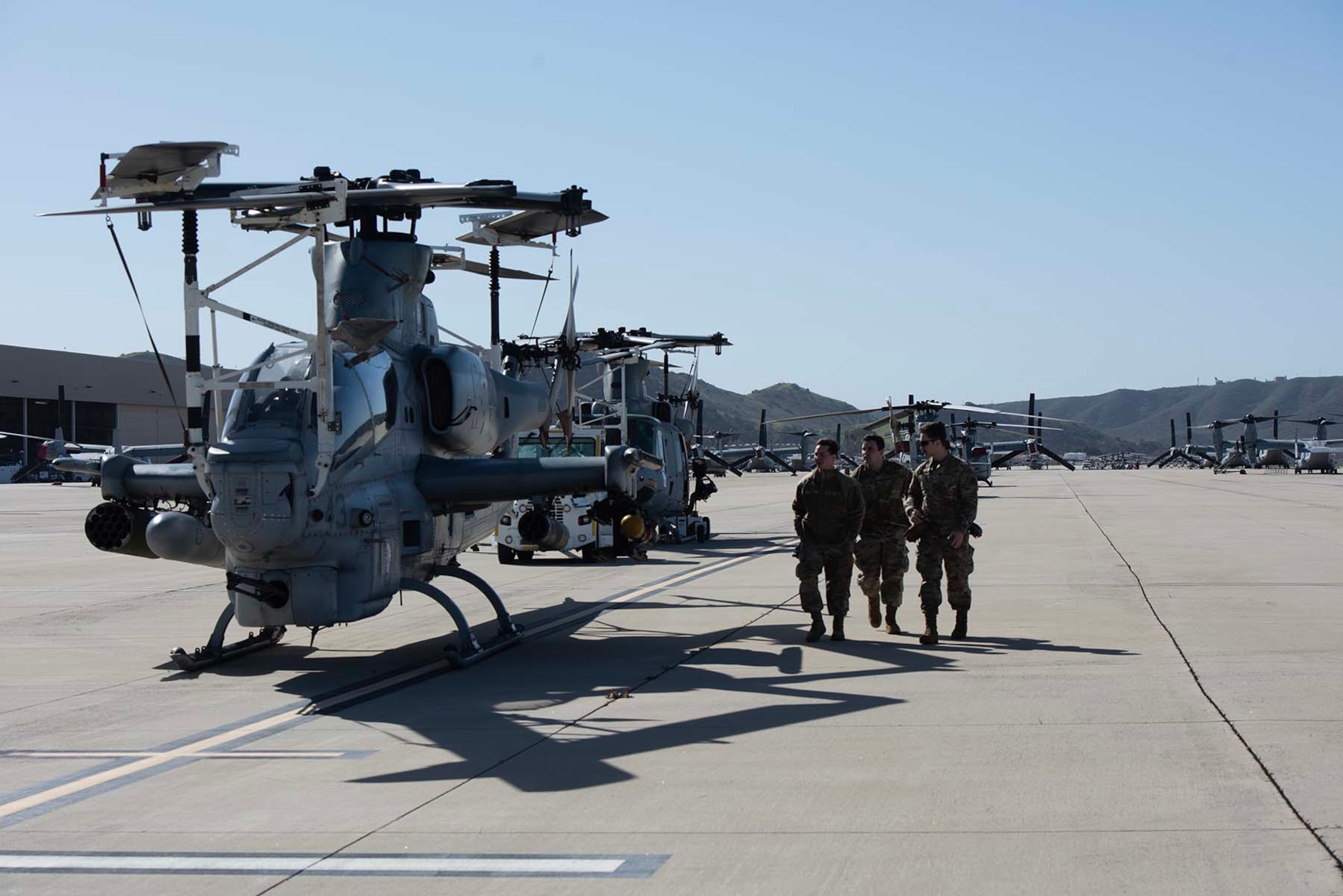 Airmen walk beside a helicopter