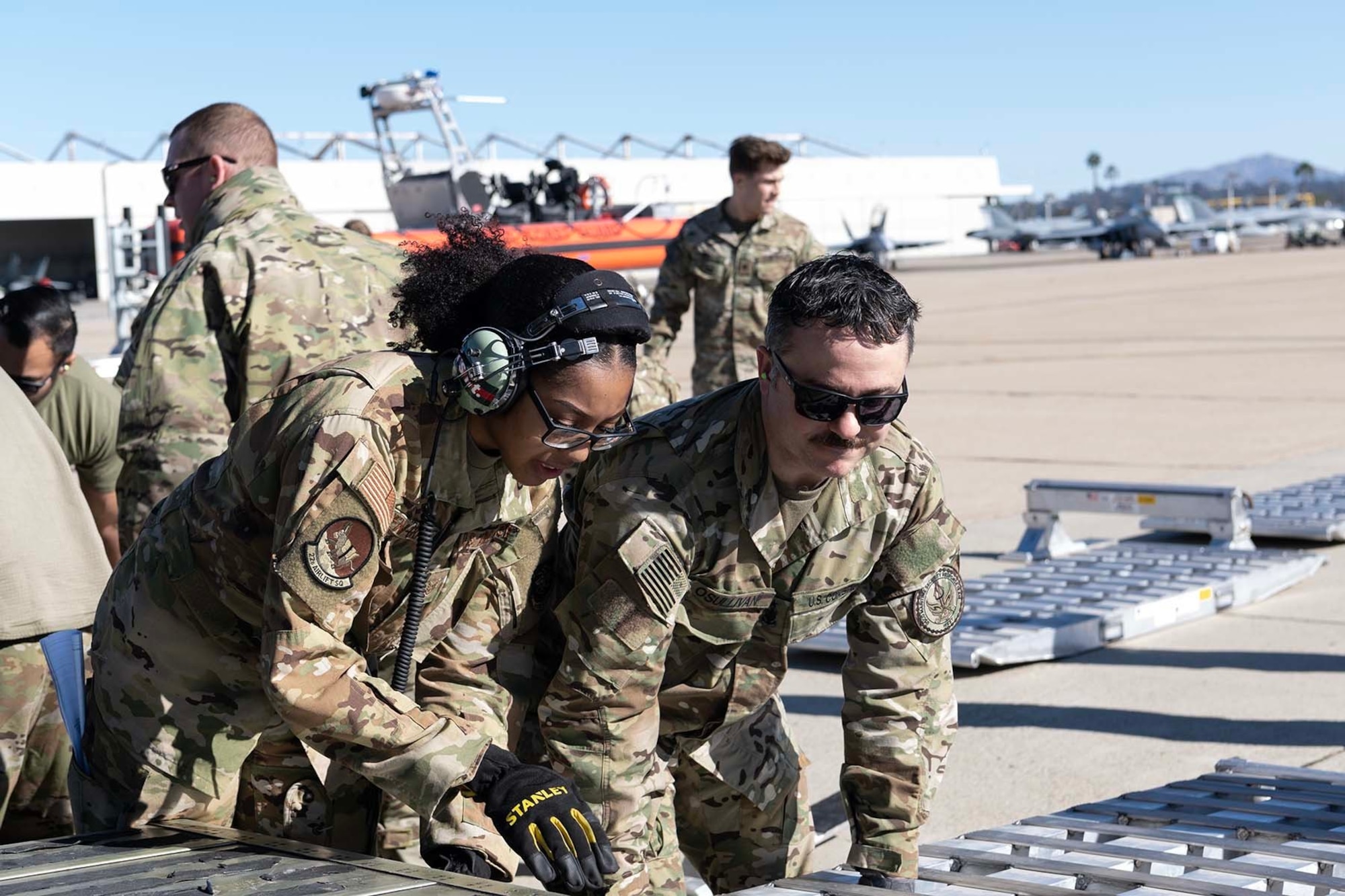Airmen and Coast Guardsmen put together a ramp to an airplane