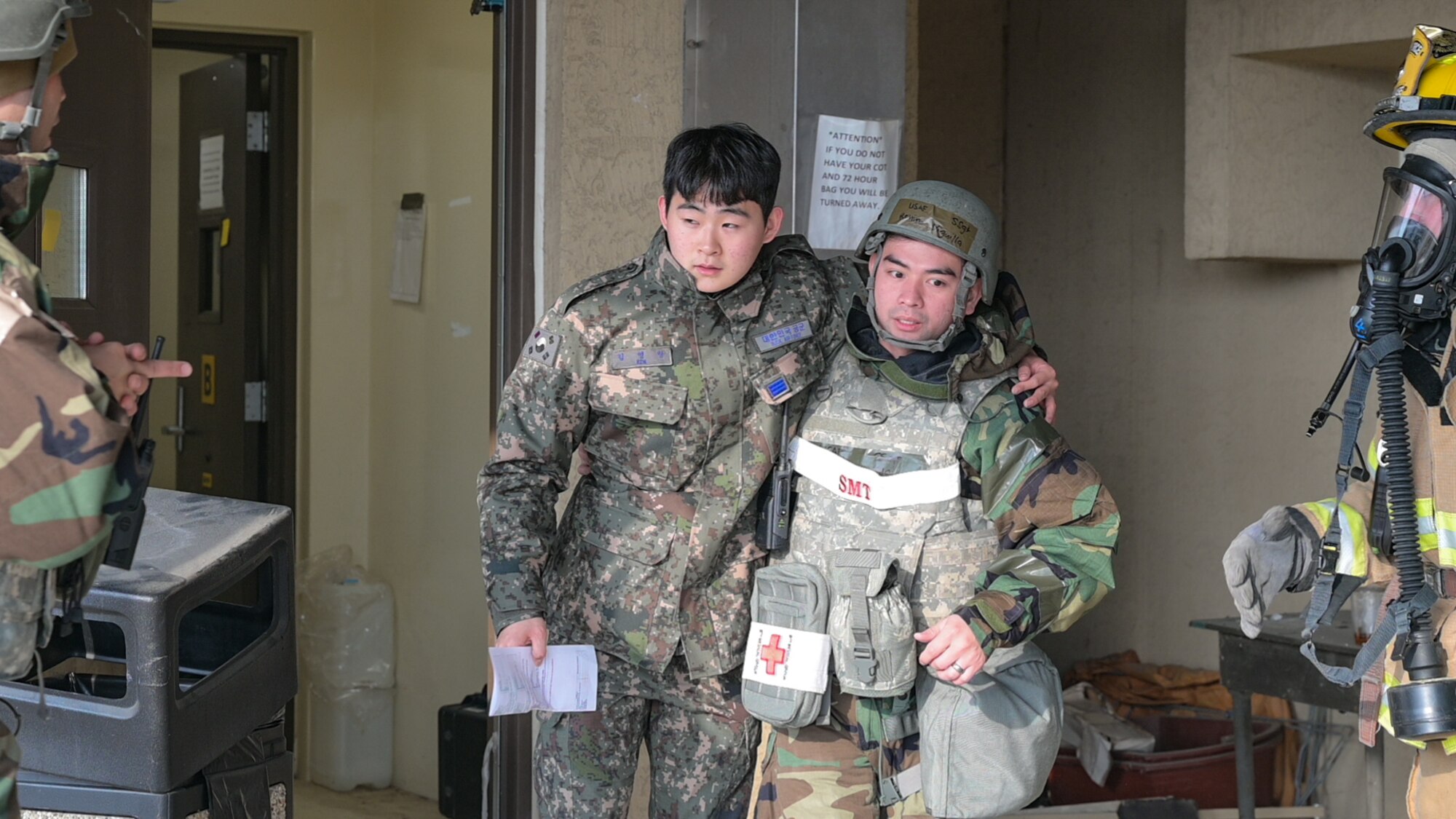 A member of the Republic of Korea (ROK) Air Force from the 38th Fighter Group (FG), simulates an injury as U.S. Air Force Staff Sgt. Reniro Viguilla, 8th Operational Medical Readiness Squadron dental technician, assists him out of a simulated burning building during a training event at Kunsan Air Base, ROK, Feb. 7, 2023. Both 38th FG and 8th Civil Engineer Squadron firefighters responded along with the 8th Medical Group, who rescued simulated injured personnel and provided expedited care. (U.S. Air Force photo by Staff Sgt. Sadie Colbert)