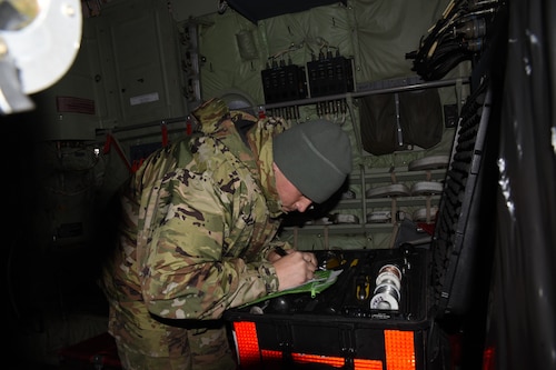 Airman counting tools in a toolbox on a WC-130J aircraft.