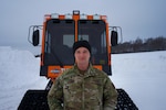 Alaska Air National Guard Staff Sgt. Benjamen Hancox, a 176th Logistics Readiness Squadron air transportation craftsman, stands near an all-terrain vehicle made for polar operations Feb. 8, 2023.