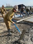 221215-N-N0748-1084 POTI, Georgia (Dec. 15, 2022) Steelworker 3rd Class Rusty Garza, assigned to Naval Mobile Construction Battalion (NMCB) 11, rakes concrete for the Railhead Project in Poti, Georgia, Dec. 15, 2022. NMCB 11 operates as a part of Navy Expeditionary Combat Command and is assigned to Commander, Task Force 68 for deployment across the U.S. Naval Forces Europe-Africa area of operations to defend U.S., allied, and partner interests. (U.S. Navy photo by Builder Constructionman Gabriella Coupe)