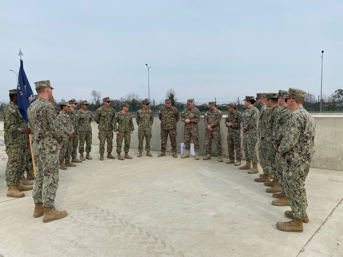 230201-N-N0748-1050 POTI, Georgia (Feb. 1, 2023) Georgian Land Force colonels address Seabees assigned to Naval Mobile Construction Battalion (NMCB) 11 before a ribbon cutting ceremony for a recently completed railhead expansion project in Poti, Georgia, Feb. 1, 2023. NMCB 11 operates as a part of Navy Expeditionary Combat Command and is assigned to Commander, Task Force 68 for deployment across the U.S. Naval Forces Europe-Africa area of operations to defend U.S., allied, and partner interests. (U.S. Navy photo by Builder Constructionman Gabriella Coupe)