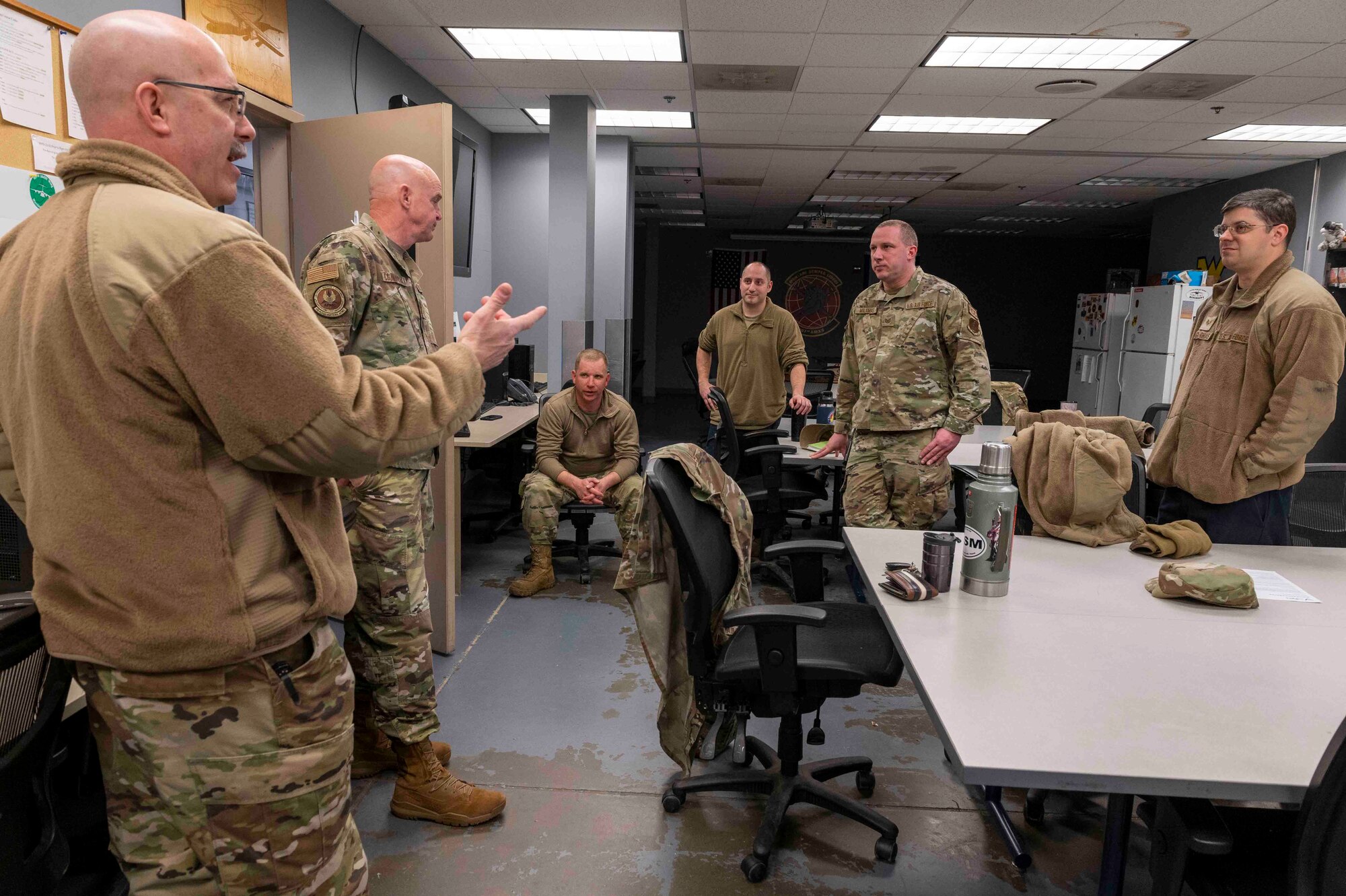 Chief Master Sgt. Ronald Bennett and Chief Master Sgt. Steven Countryman, left, National Guard Bureau Production Assessment Team superintendents, talk with 167th Aircraft Maintenance Squadron crew chiefs, during an assessment to improve aircraft availability at the 167th Airlift Wing, Martinsburg, W.Va., Jan. 24, 2023