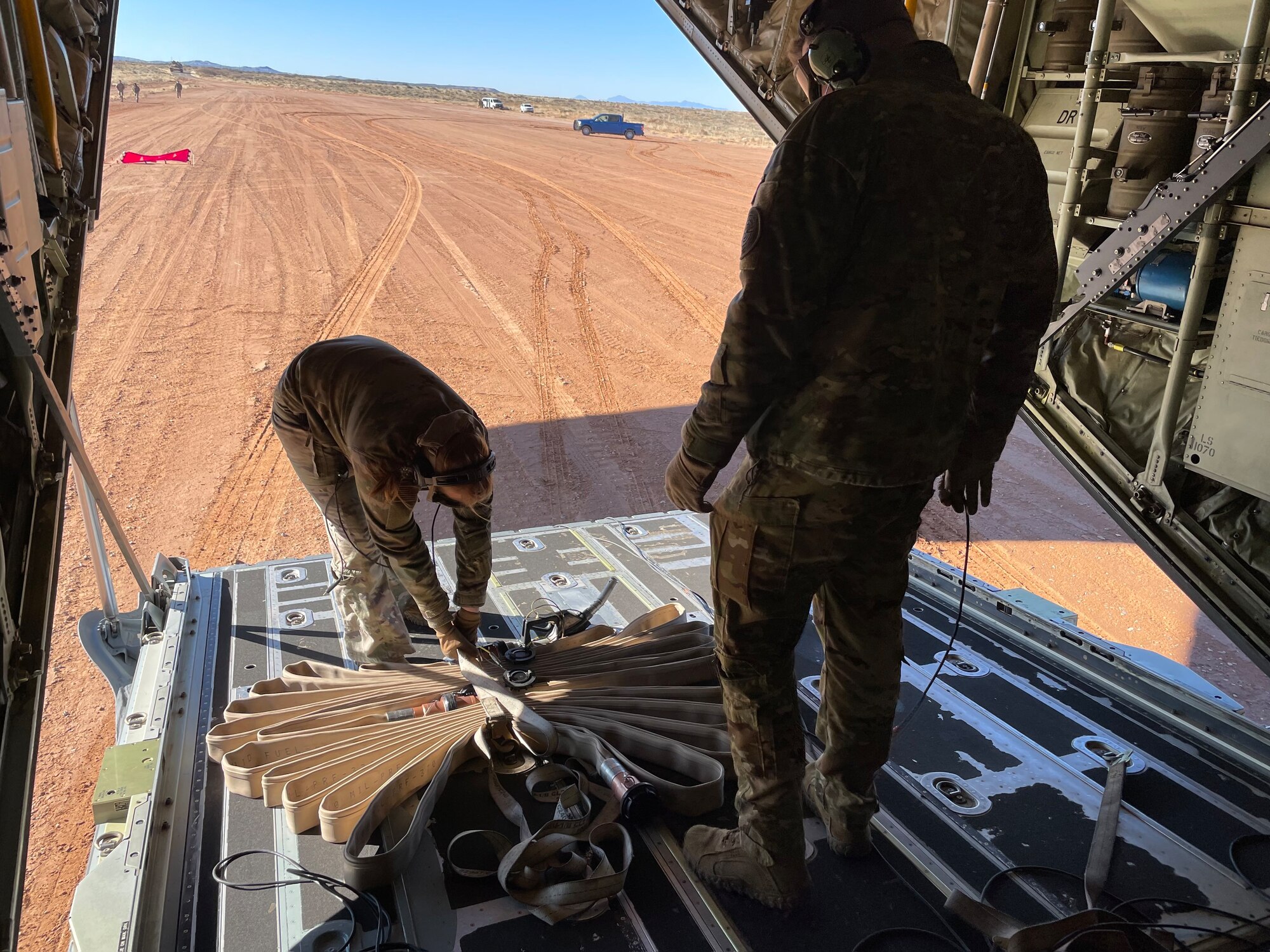 U.S. Air Force Airmen assigned to the 317th Airlift Wing unload a fuel hose from the cargo bay of a C-130J Super Hercules at Fort Bliss, Texas, Jan. 25, 2023. The 317th AW executed an Agile Combat Employment exercise by sending a C-130 to the Fort Bliss Range to perform Specialized Fueling Operations with the 3rd Brigade Combat Team, 1st AD and the 1st Battalion, 77th Armored Regiment. The units successfully passed fuel from a C-130 to an M1A2 Abrams Tank utilizing an Emergency Response Refueling Equipment Kit, marking the first time in Air Force history that a C-130 has been used to refuel an Abrams tank. (Courtesy photo)