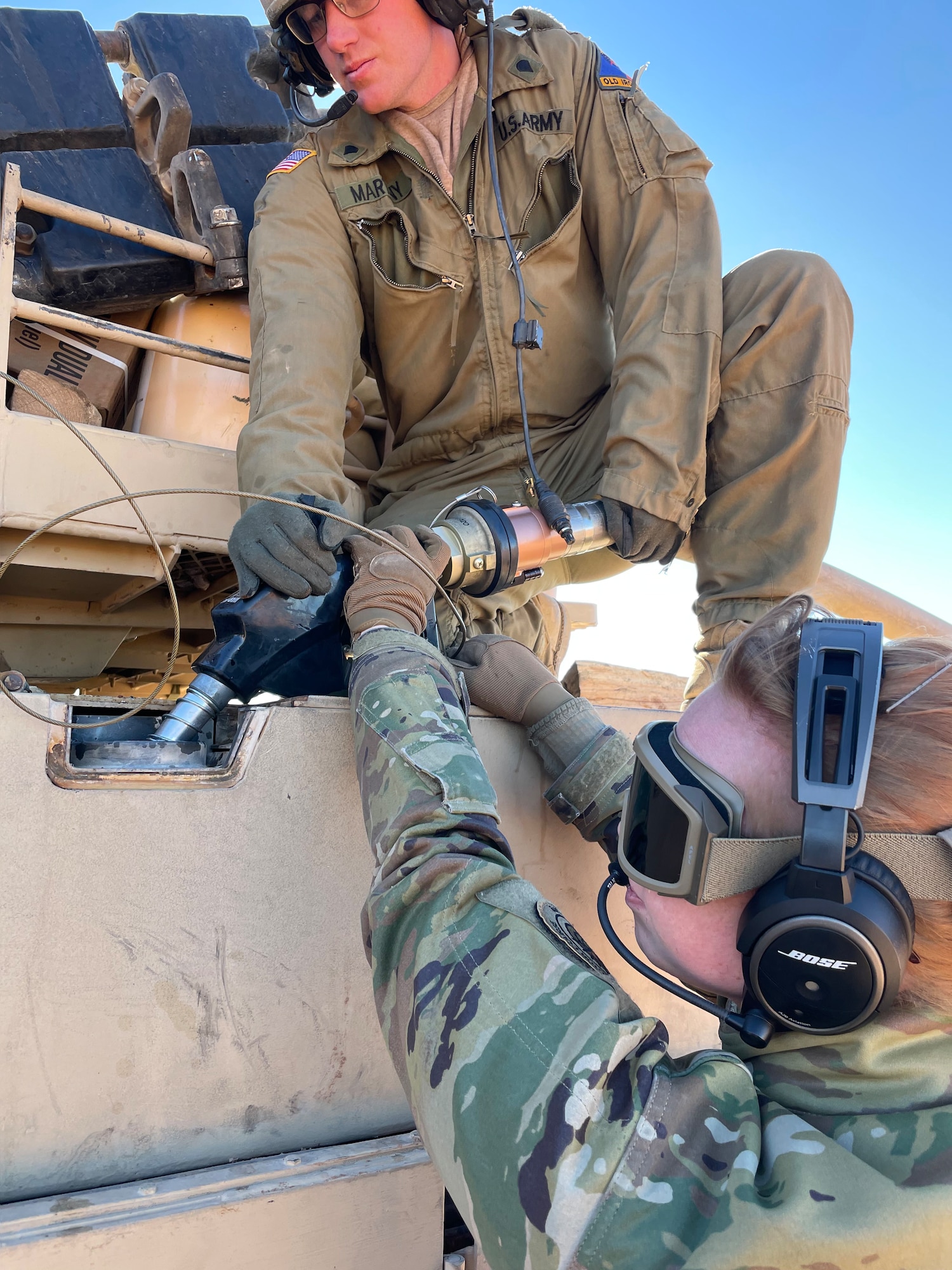 U.S. Army soldiers assigned to the 1st Armored Division connect a fuel hose to an M1A2 Abrams Tank at Fort Bliss, Texas, Jan. 25, 2023. The 317 Airlift Wing executed an Agile Combat Employment exercise by sending a C-130 to the Fort Bliss Range to perform Specialized Fueling Operations with the 3rd Brigade Combat Team, 1st AD and the 1st Battalion, 77th Armored Regiment. The units successfully passed fuel from a C-130 to an M1A2 Abrams Tank utilizing an Emergency Response Refueling Equipment Kit, marking the first time in Air Force history that a C-130 has been used to refuel an Abrams tank. (Courtesy photo)