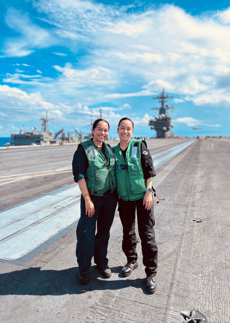 Aviation Boatswain's Mate (Equipment) 2nd Class Angelica Aguirre, left, and Master-At-Arms 2nd Class Arianna Aguirre, both assigned to the Nimitz-class aircraft carrier USS George H. W. Bush (CVN 77), pose on the flight deck, June 28, 2022. The George H.W. Bush Carrier Strike Group is on a scheduled deployment in the U.S. Naval Forces Europe area of operations, employed by U.S. Sixth Fleet to defend U.S., allied and partner interests.