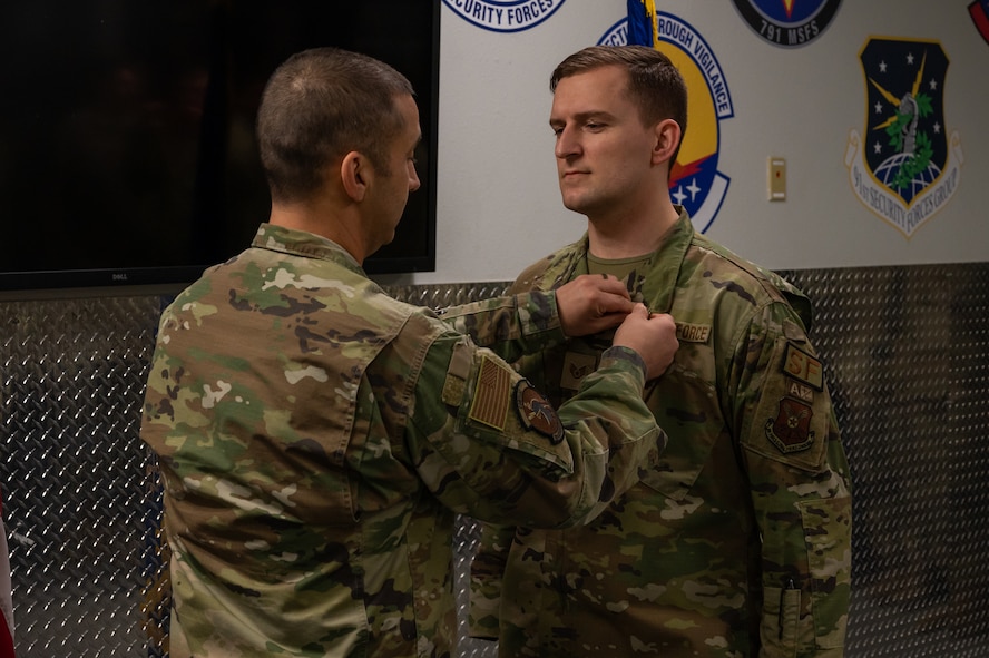 U.S. Air Force Staff Sgt. Nicholas Thompson, 5th Security Forces Squadron response team leader (right), is awarded the Air And Space Achievement Medal at Minot Air Force Base, North Dakota, Feb. 10, 2023. Thompson was awarded the medal for taking heroic action that saved a fellow Airman's life. (U.S. Air Force Photo by Airman 1st Class Alexander Nottingham)