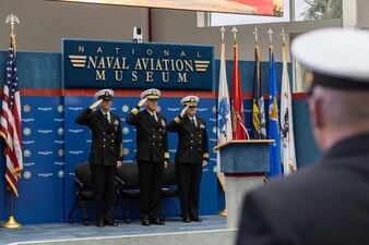 Rear Adm. Pete Garvin, center, commander, Naval Education and Training Command (NETC), Force Master Chief Matthew Harris, left, NETC’s force master chief, and Cmdr. Stephen Fisher, NETC’s chaplain, salute during the national anthem for the Military Instructor of the Year 2022 awards ceremony at the National Naval Aviation Museum onboard Naval Air Station Pensacola, February 10, 2023. NETC’s mission is to recruit, train and deliver those who serve our nation, taking them from street-to-fleet by transforming civilians into highly skilled, operational and combat ready warfighters. (United States Navy photo by Mass Communication Specialist 2nd Class Zachary Melvin)