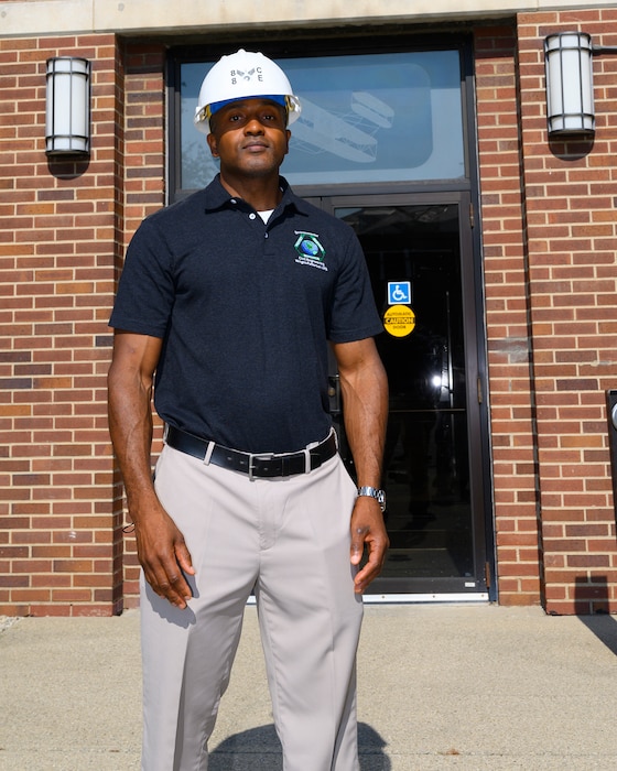 Mott wears a hard hat standing in front of the 88th Air Base Wing headquarters building.