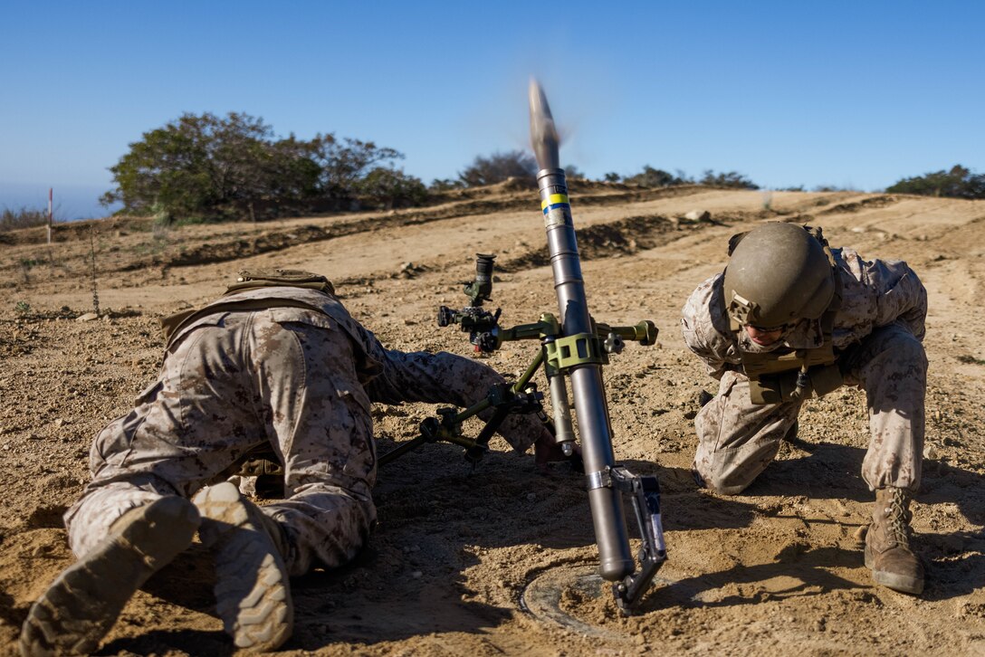 U.S. Marine mortarman with Weapons Company, 1st Battalion, 5th Marine Regiment, 1st Marine Division, fires an M224 60 mm lightweight mortar during a training exercise on Marine Corps Base Camp Pendleton, California, Feb. 6, 2023. The exercise was conducted to evaluate the accuracy and efficiency of mortarmen when using a drone to direct their fire toward a target. (U.S. Marine Corps photo by Lance Cpl.Torres)