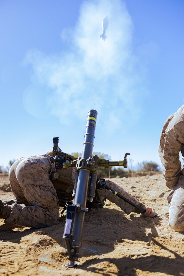 U.S. Marine mortarman with Weapons Company, 1st Battalion, 5th Marine Regiment, 1st Marine Division, fires an M224 60 mm lightweight mortar during a training exercise on Marine Corps Base Camp Pendleton, California, Feb. 6, 2023. The exercise was conducted to evaluate the accuracy and efficiency of mortarmen when using a drone to direct their fire toward a target. (U.S. Marine Corps photo by Lance Cpl.Torres)